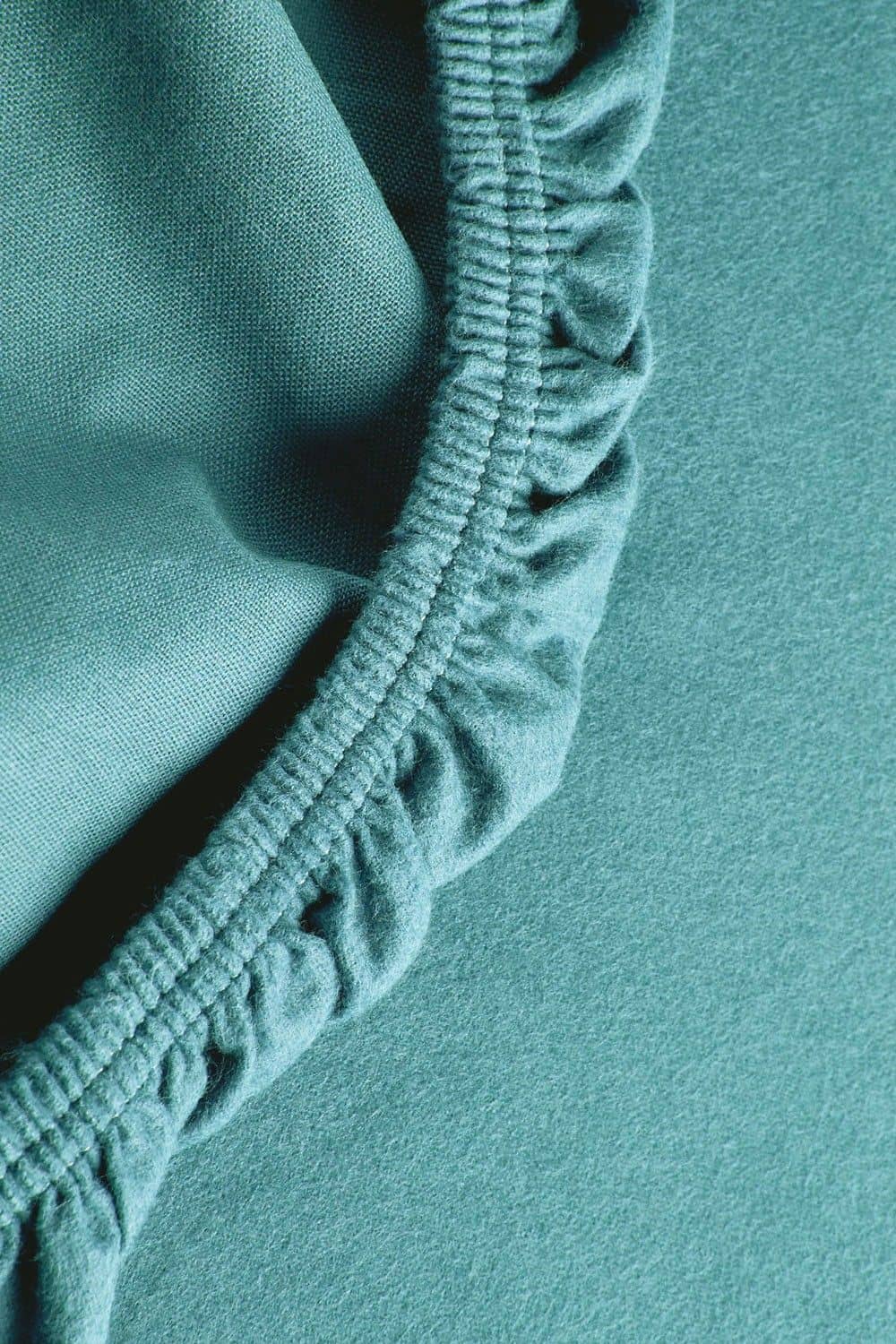 Detailaufnahme vom Gummizug des türkisen Biber Spannbettlaken aus bio Baumwolle (kbA)