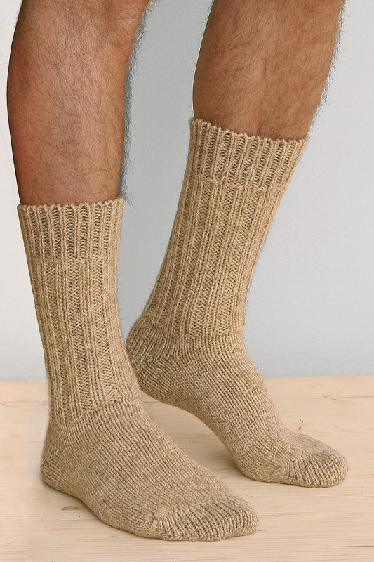 Dicke Finkhof-Socken aus reiner Bio-Schurwolle Person trägt beige dicke Finkhof Socken aus bio Wolle (kbT) auf Holzboden von der Seite