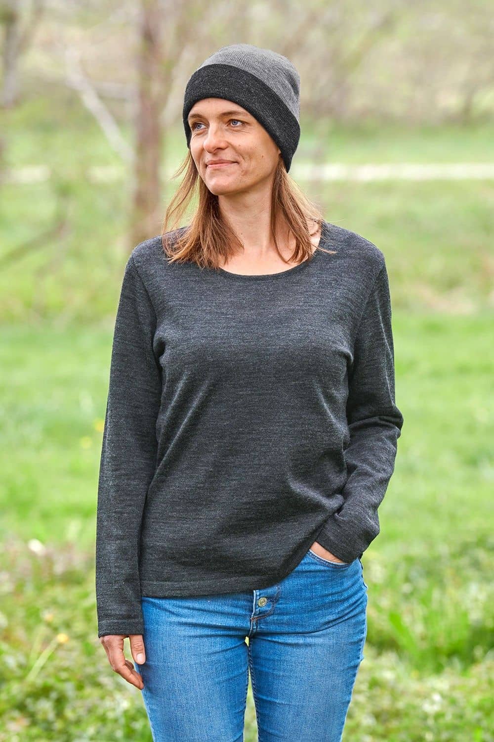 Frau mit grauem Shirt trägt eine graue Wendemütze aus bio Wolle (kbT) vom Finkhof