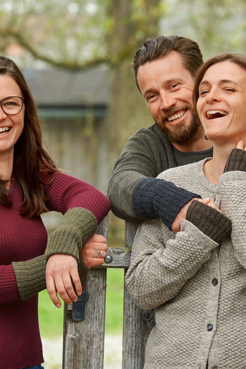 Warme Pulswärmer warme Finkhof Pulswärmer aus bio Wolle (kbT) getragen auf Gruppenbild mit Frauen und einem Mann mit Strickpullis