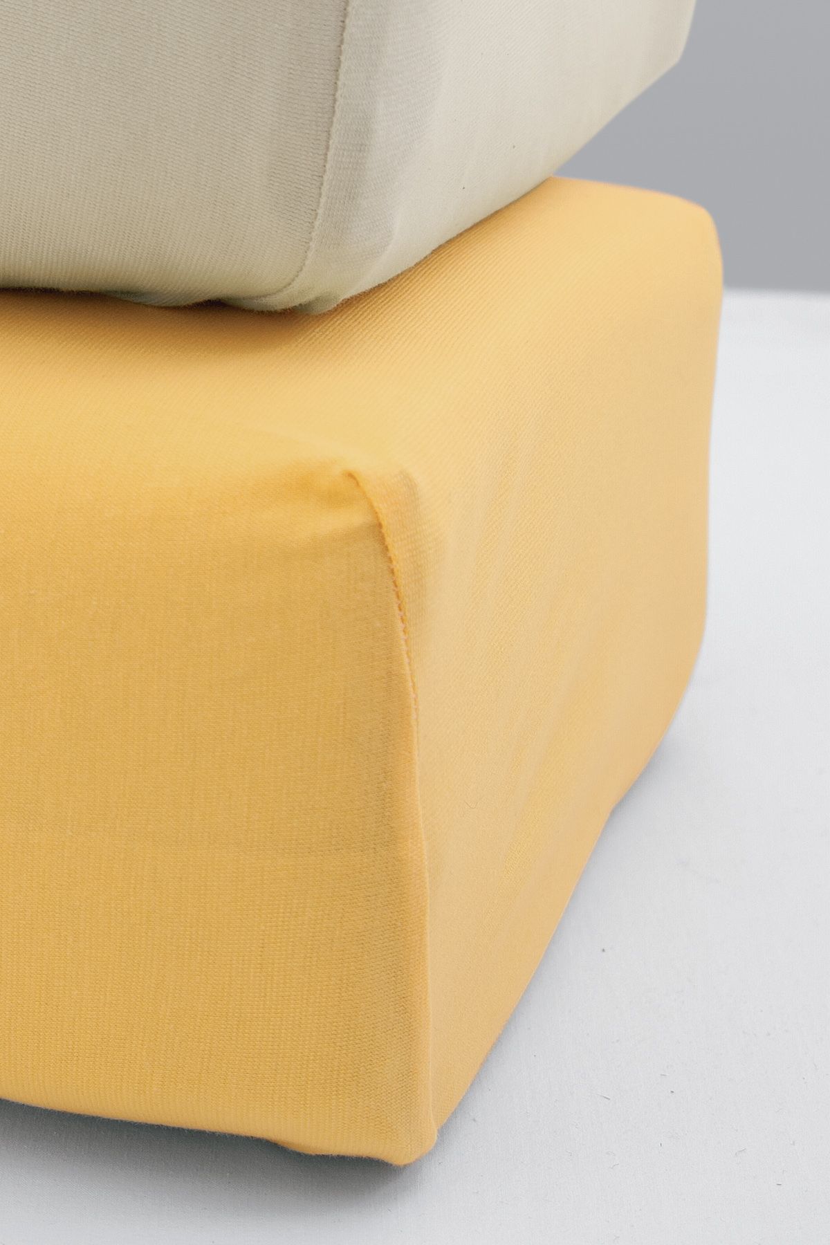 gelbes Spannbetttuch aus bio Baumwolle (kbA) an einer Matratzenecke