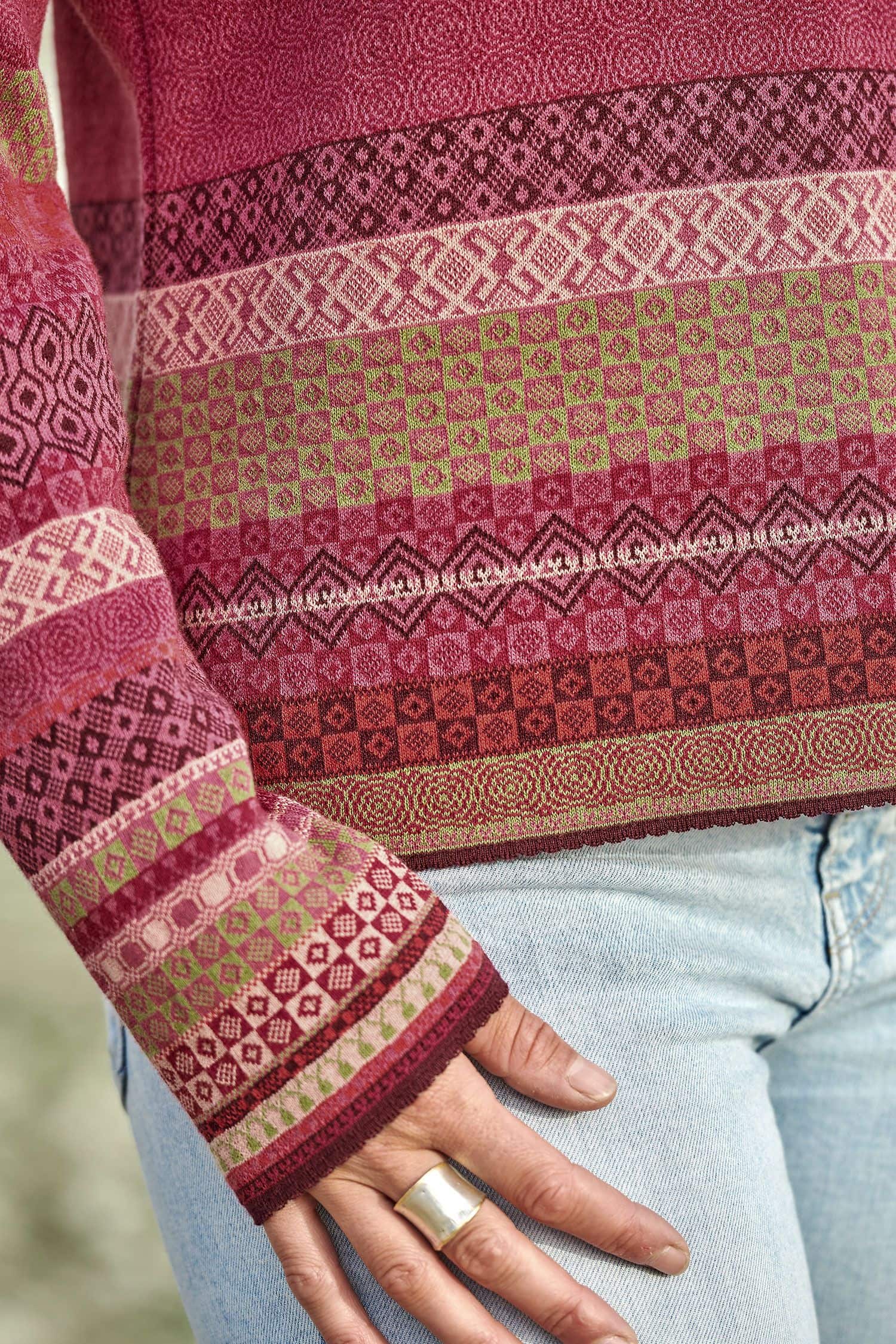 Detailaufnahme der Ärmel des gemusterten Strickpullis in beere und pink aus bio Baumwolle (kbA)