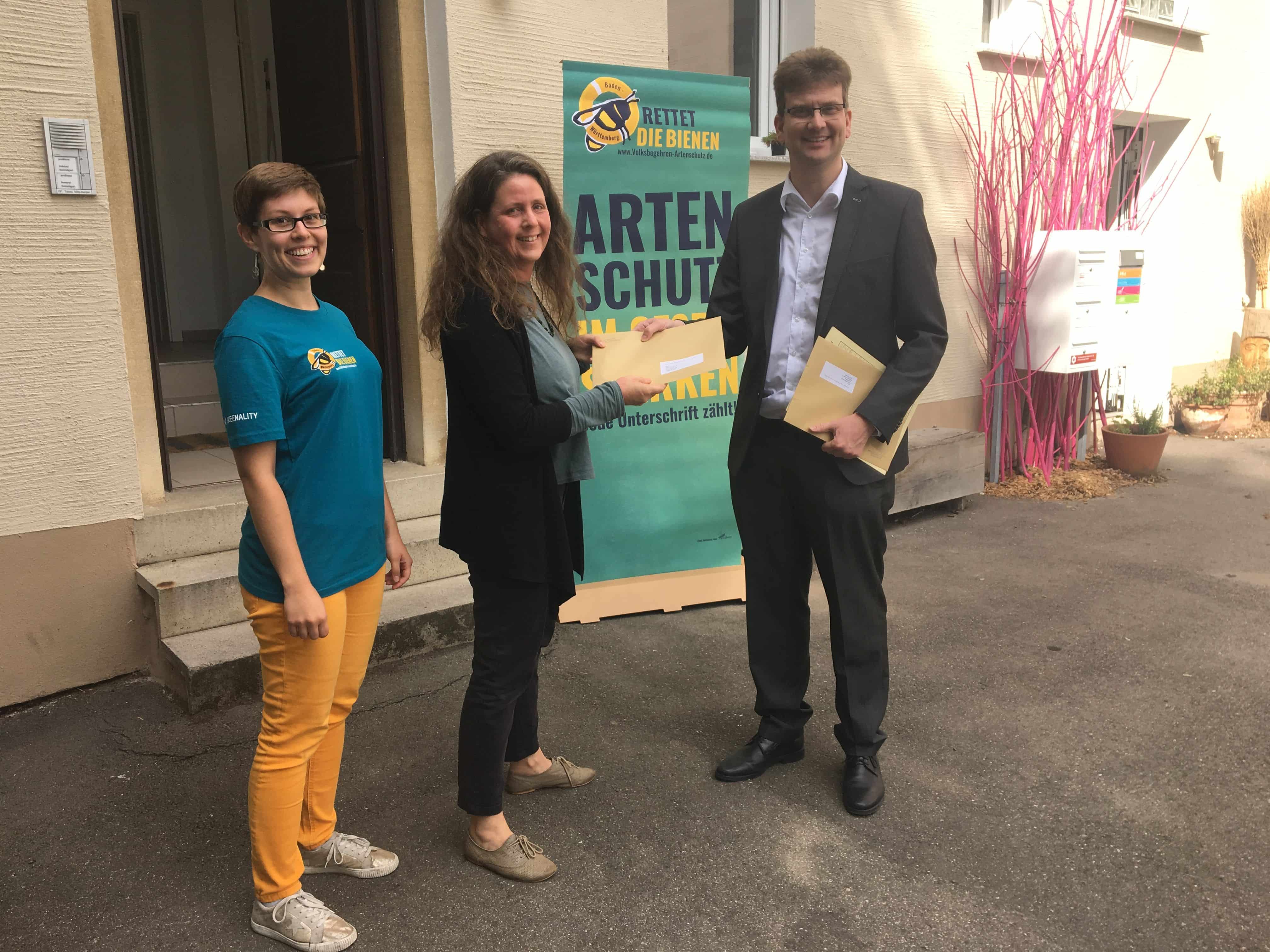 Überreichung eines Kuverts im Rahmen eines Volksbegehren für Artenschutz (Rettet die Bienen Banner im Hintergrund)