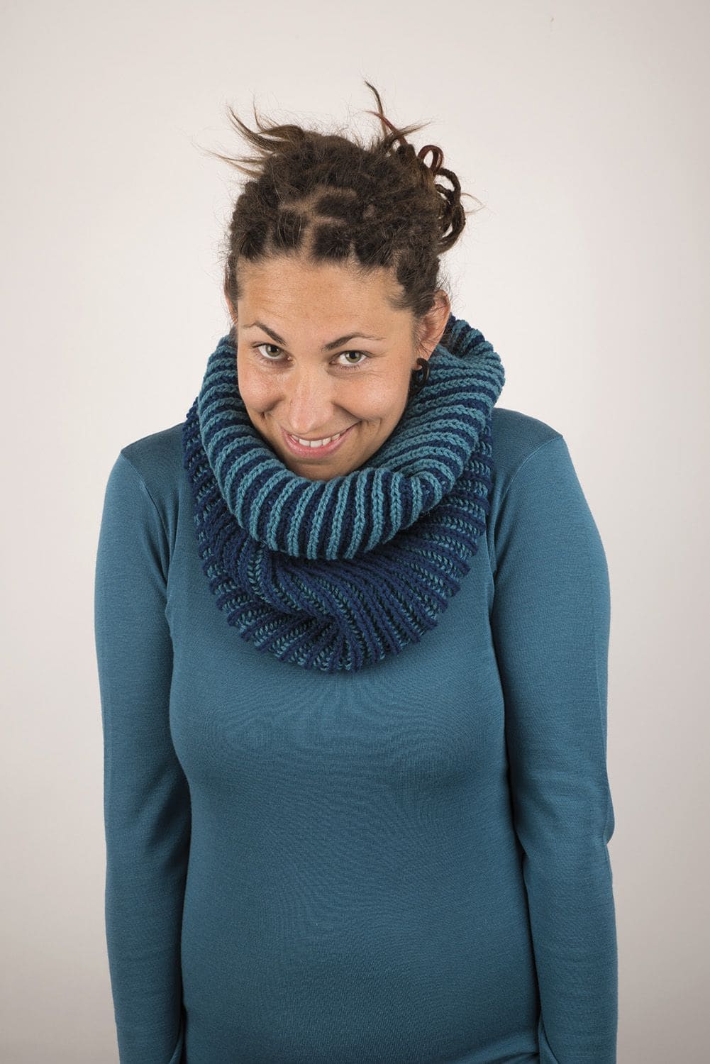 Frau trägt blaues Shirt und blauen Loopschal, von vorne