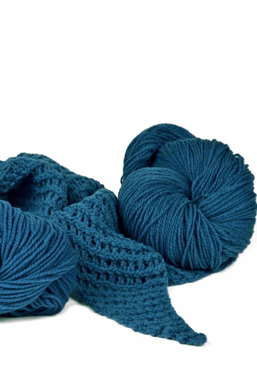 Finkhof Merinowolle dünn gefärbt stahlblau dünne stahlblaue Finkhof Merinowolle aus bio Wolle (kbT) mit Strickstück davor, weißer Untergrund