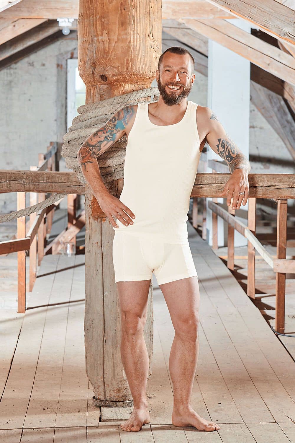 Baumwolle Pur Herren-Pants Mann an Holzbalken gelehnt trägt Unterhemd und Unterhose aus bio Baumwolle (kbA) in natur (beige)