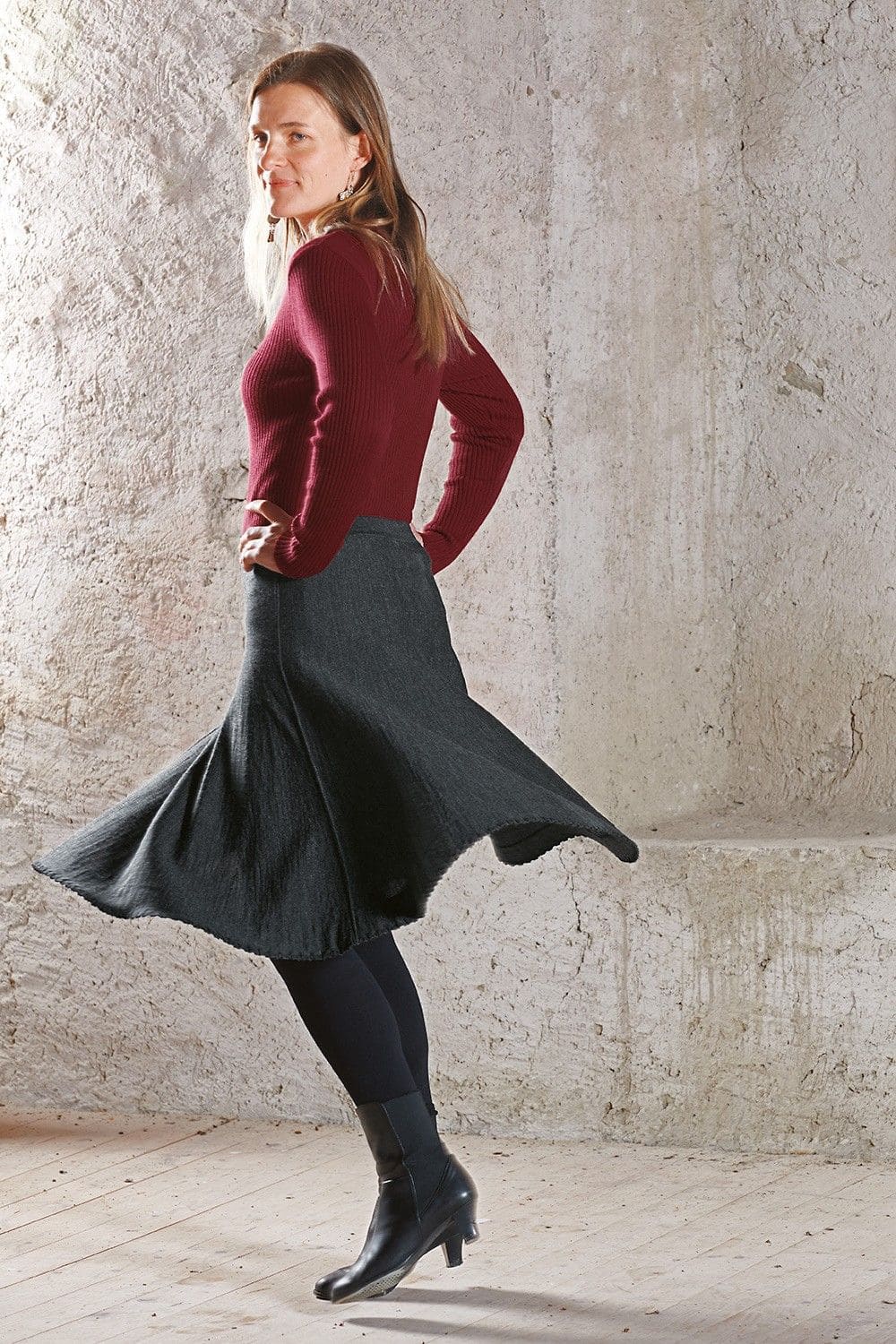 Frau mit grauem Rock, Finkhof Shirt mit Rippstoff und V Ausschnitt aus bio Wolle (kbT), in Bewegung von der Seite