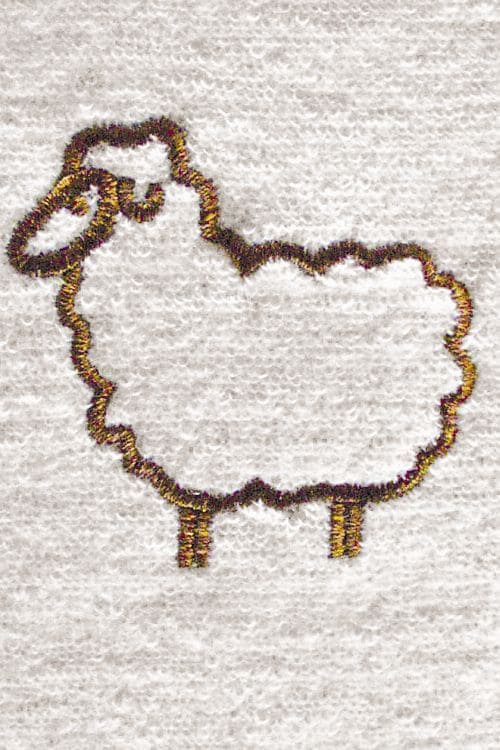 Detailbild von gesticktem Schaf auf hellem Untergrund