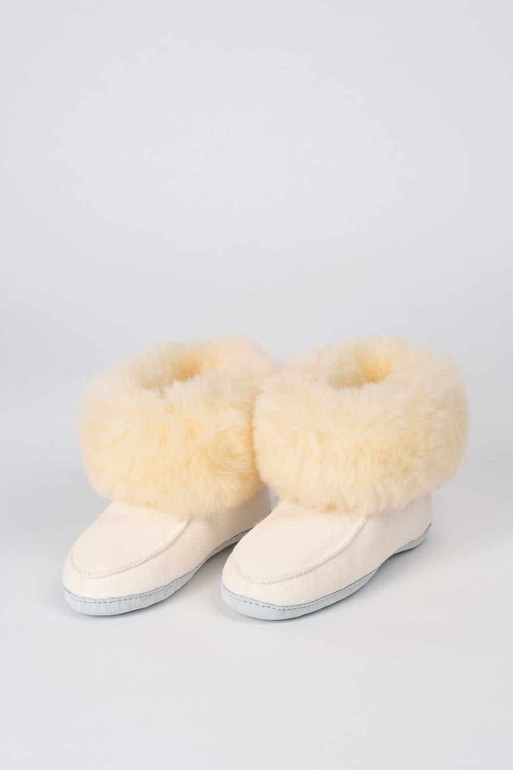 Weiße Finkhof-Fellschuhe aus Schaffell und Rindsleder, als Paar leicht versetzt vor hellem Hintergrund