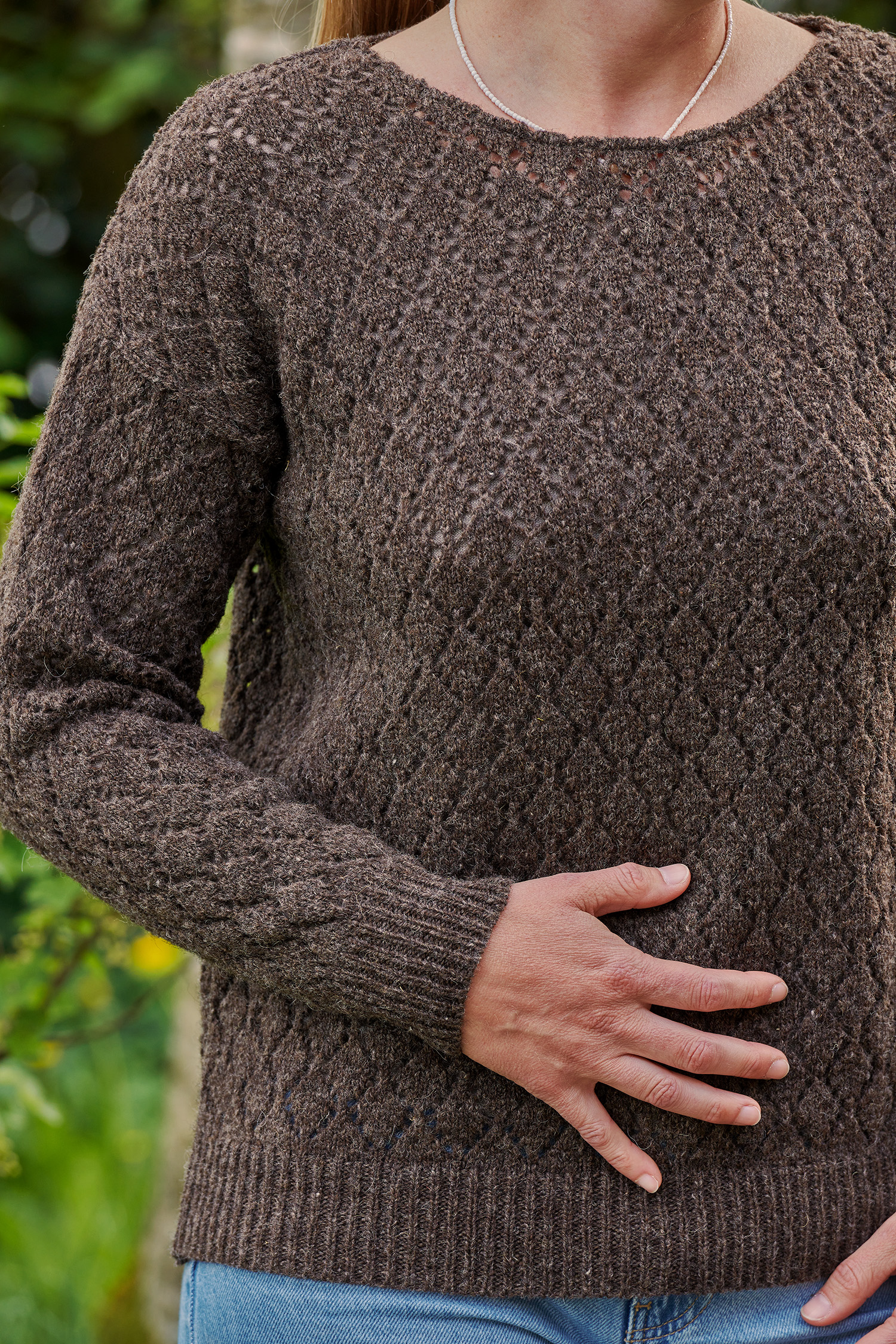 Nahaufnahme der Struktur des braunen ungefärbten Strickpullover mit Ajourmuster aus Bio-Wolle vom Finkhof