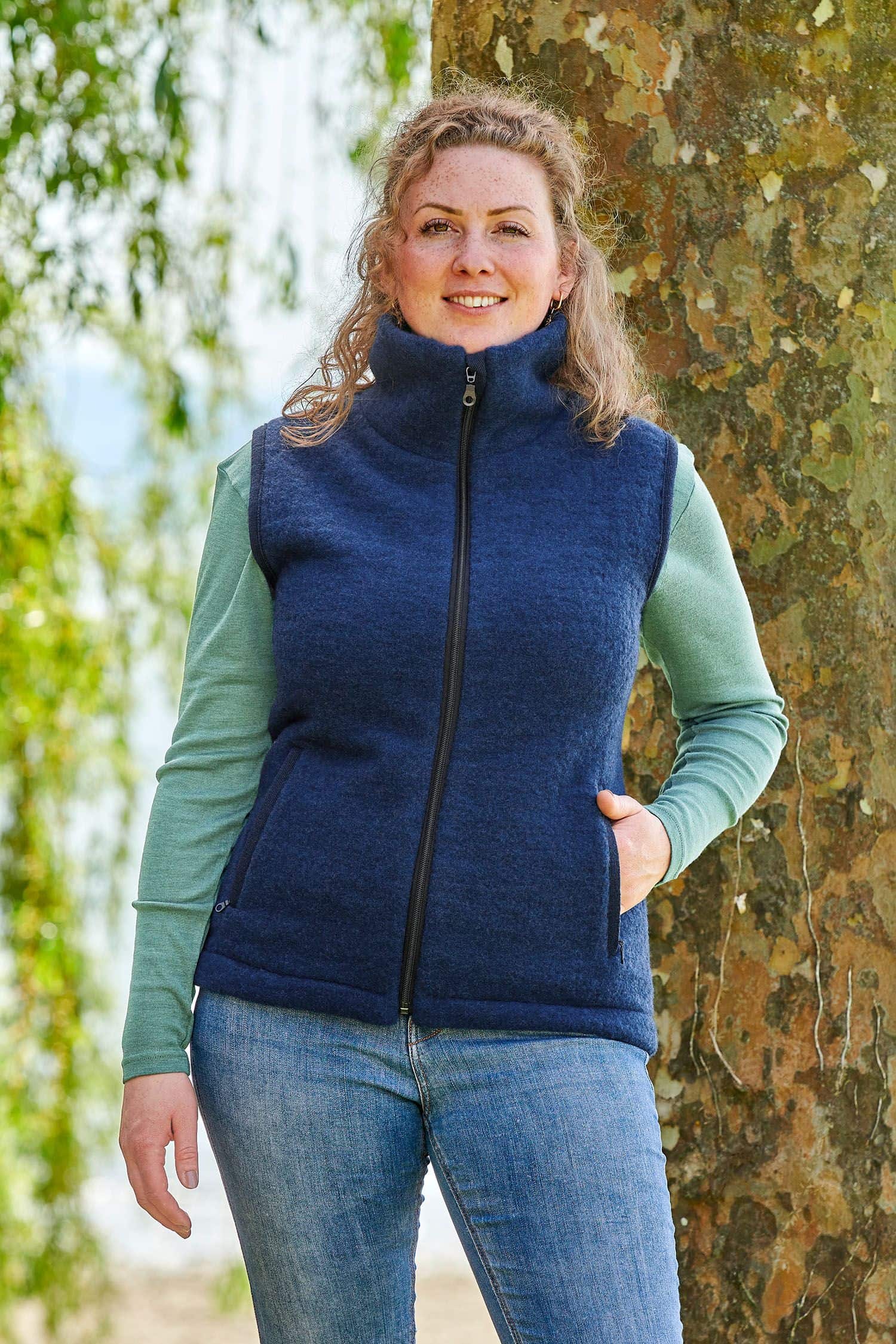 Frau mit grünem Shirt trägt eine blaue ärmellose Weste aus bio Wolle (kbT) vom Finkhof