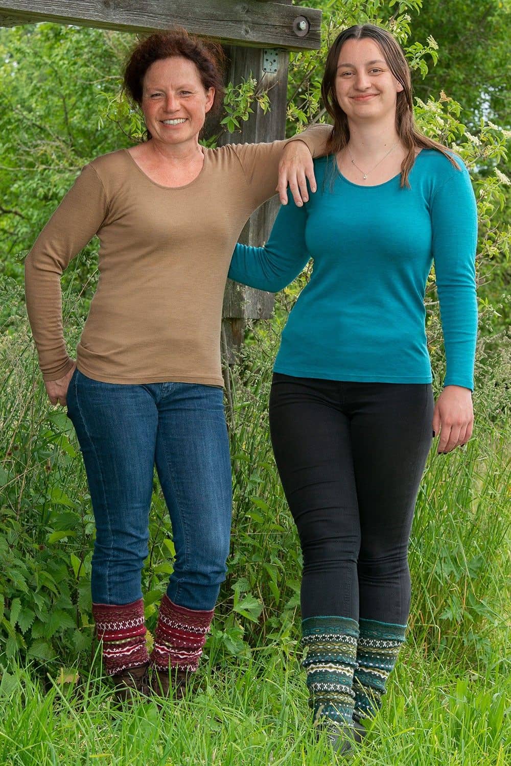 Frauen mit türkisen und braunen Shirts und Jeans tragen rote und grüne Beinstulpen nordic aus bio Wolle (kbT)