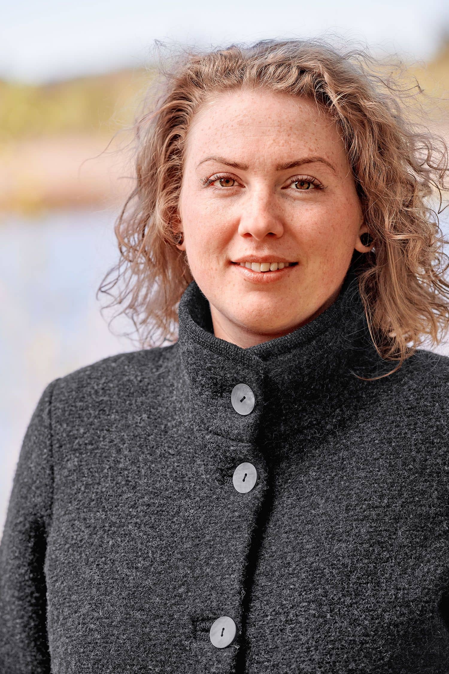 Portraitaufnahme von Frau mit dunkelgrauem Finkhof Wollwalkmantel aus bio Wolle (kbT)