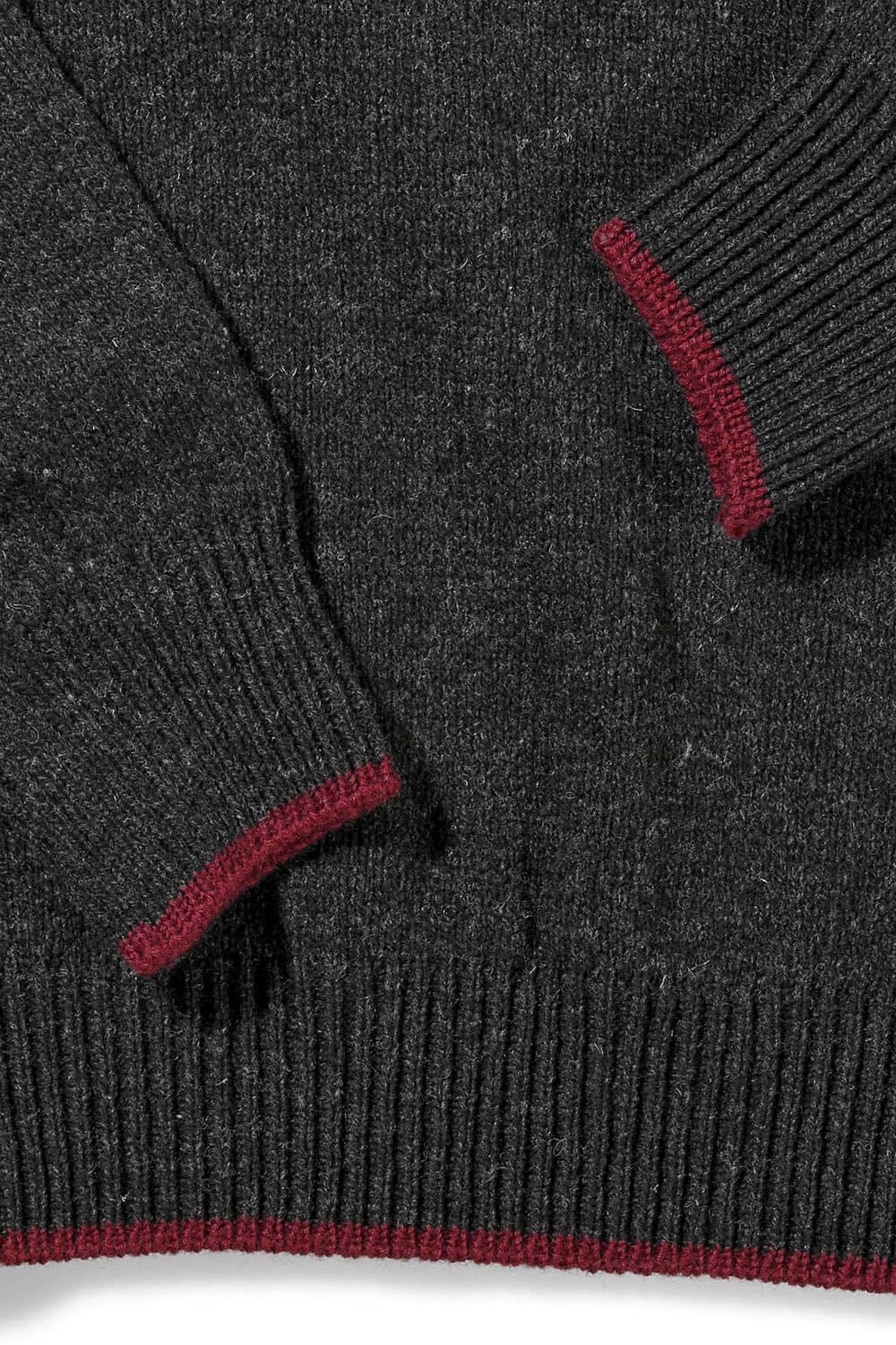 Detailaufnahme der weinroten Kanten des anthrazitgrauen Finkhof Pullis aus bio Wolle (kbT)