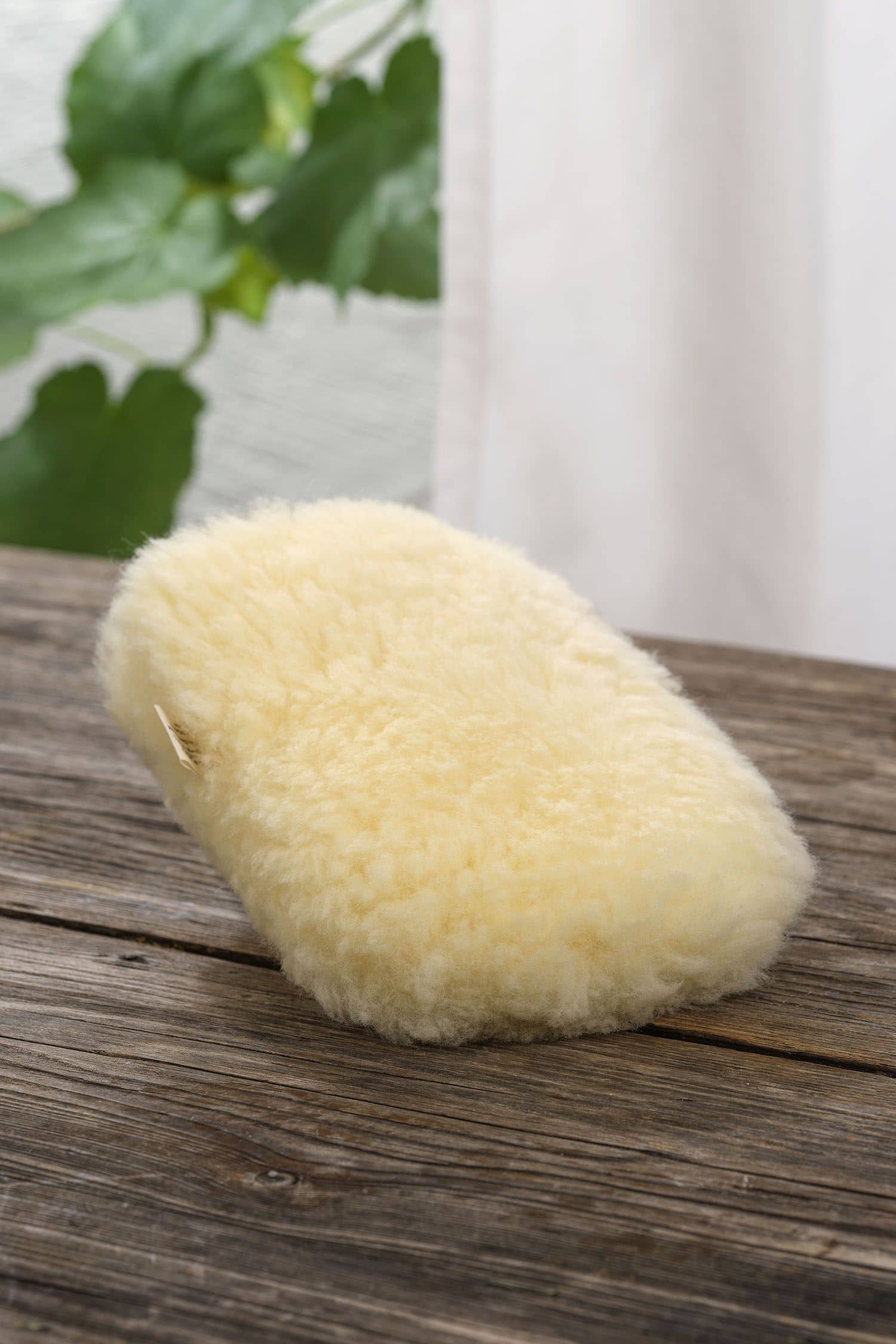 gelblicher Staubhandschuh vom Finkhof aus relugan gegerbtem Schaffell auf braunem Holzboden