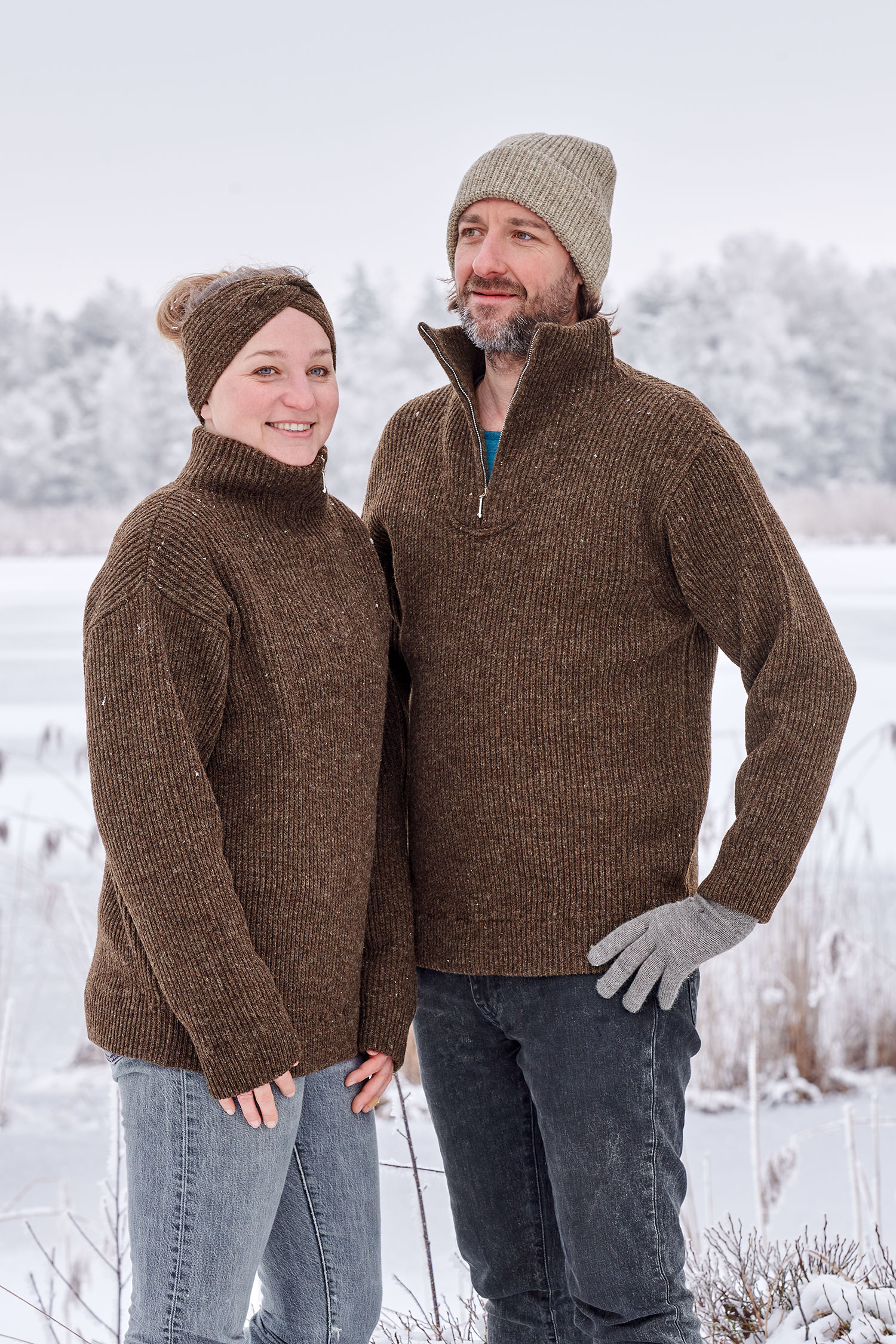 Finkhof-Troyer braun Gr. L Frau und Mann mit Mütze, Twiststirnband und braunen Finkhof Troyern aus bio Wolle (kbT) in Schneelandschaft