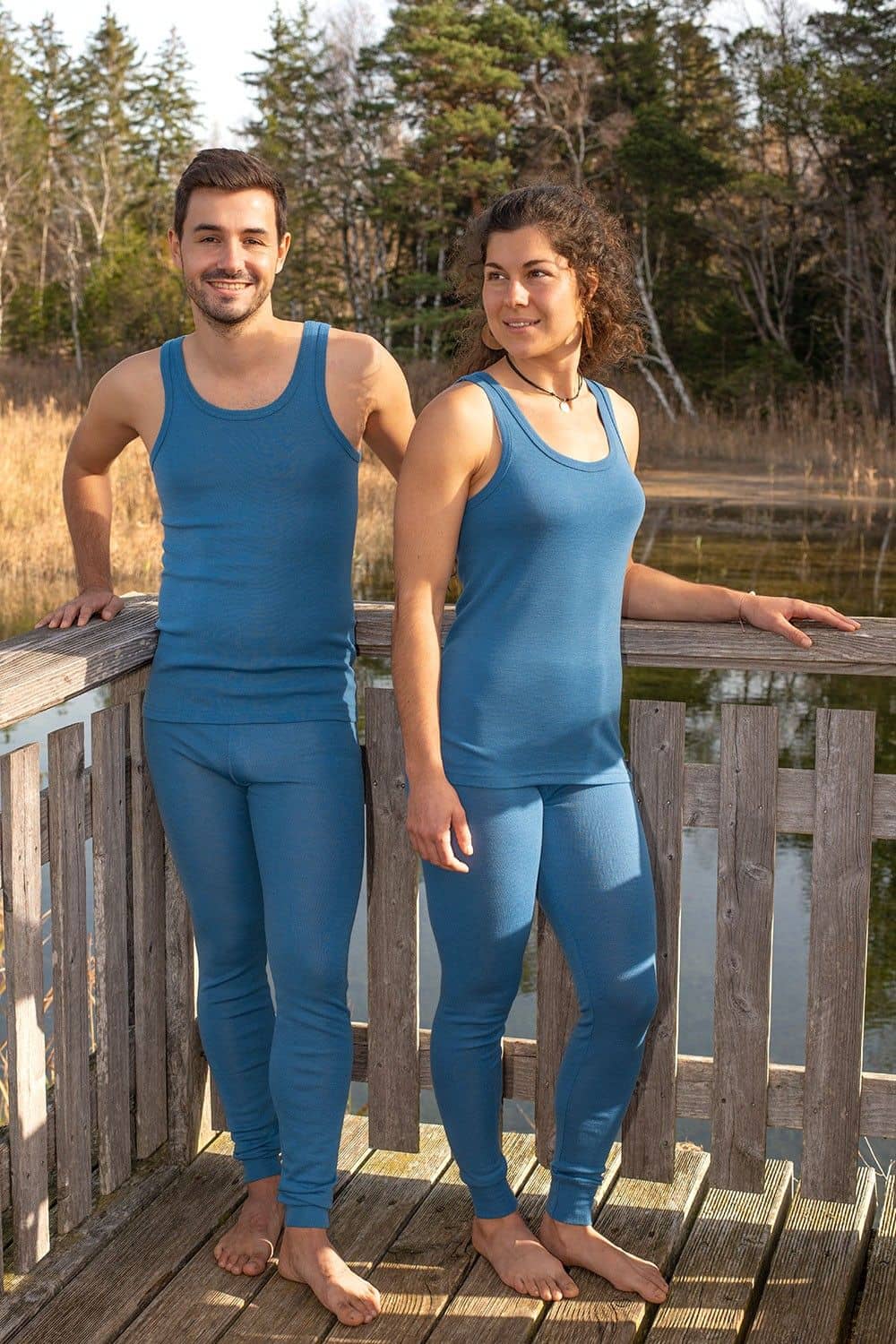 Mann und Frau stehen auf einer Brücke und tragen blaue Unterhemden aus bio Wolle (kbT) mit langer Unterhose