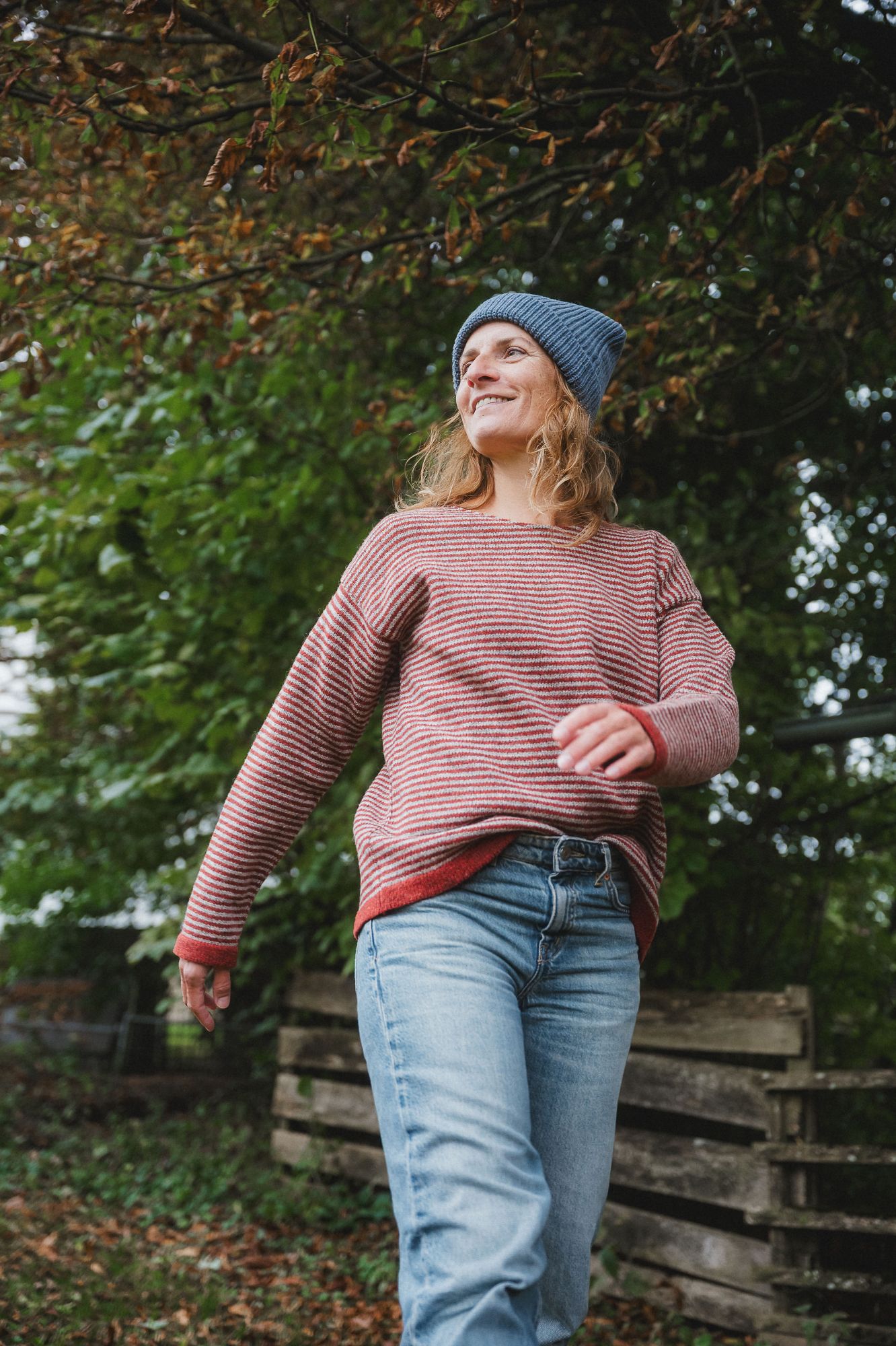 Frau mit Jeans und blauer Mütze trägt rot weiß gestreiften Pulli aus bio Wolle (kbT) vom Finkhof