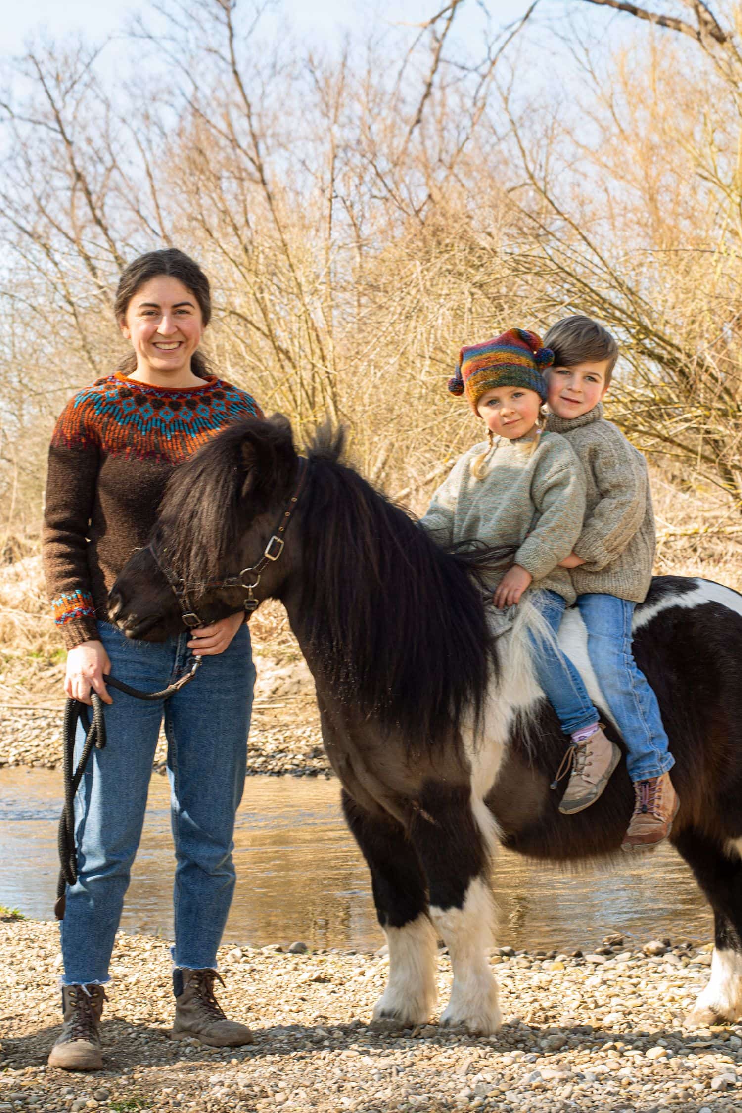 Frau mit Kindern auf Pony trägt braunen Pulli mit nordischem Muster als Beispiel für das Buch ,,Einfach nordisch stricken"