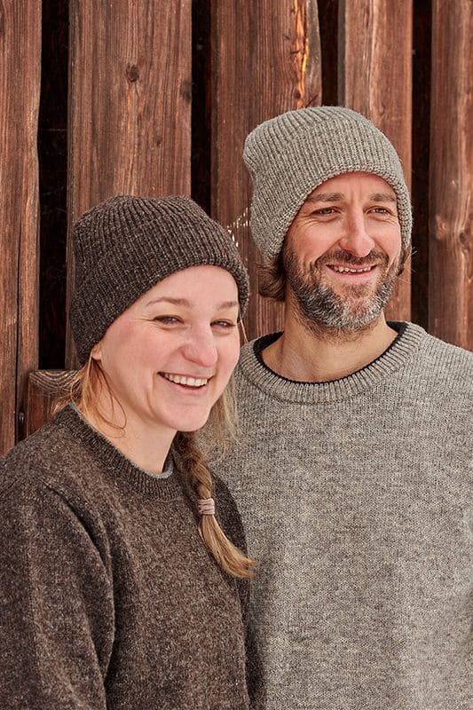 Finkhof-Mütze Mann und Frau mit Wollpullis tragen Finkhof Mützen aus bio Wolle (kbT)