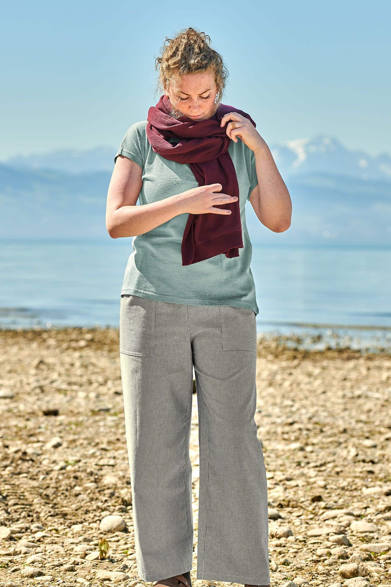 Damen-Baumwollhose blau/natur Gr. M Frau trägt eine blau weiße Stoffhose aus bio Baumwolle (kbA) vom Finkhof mit blauem Shirt und rotem Schal