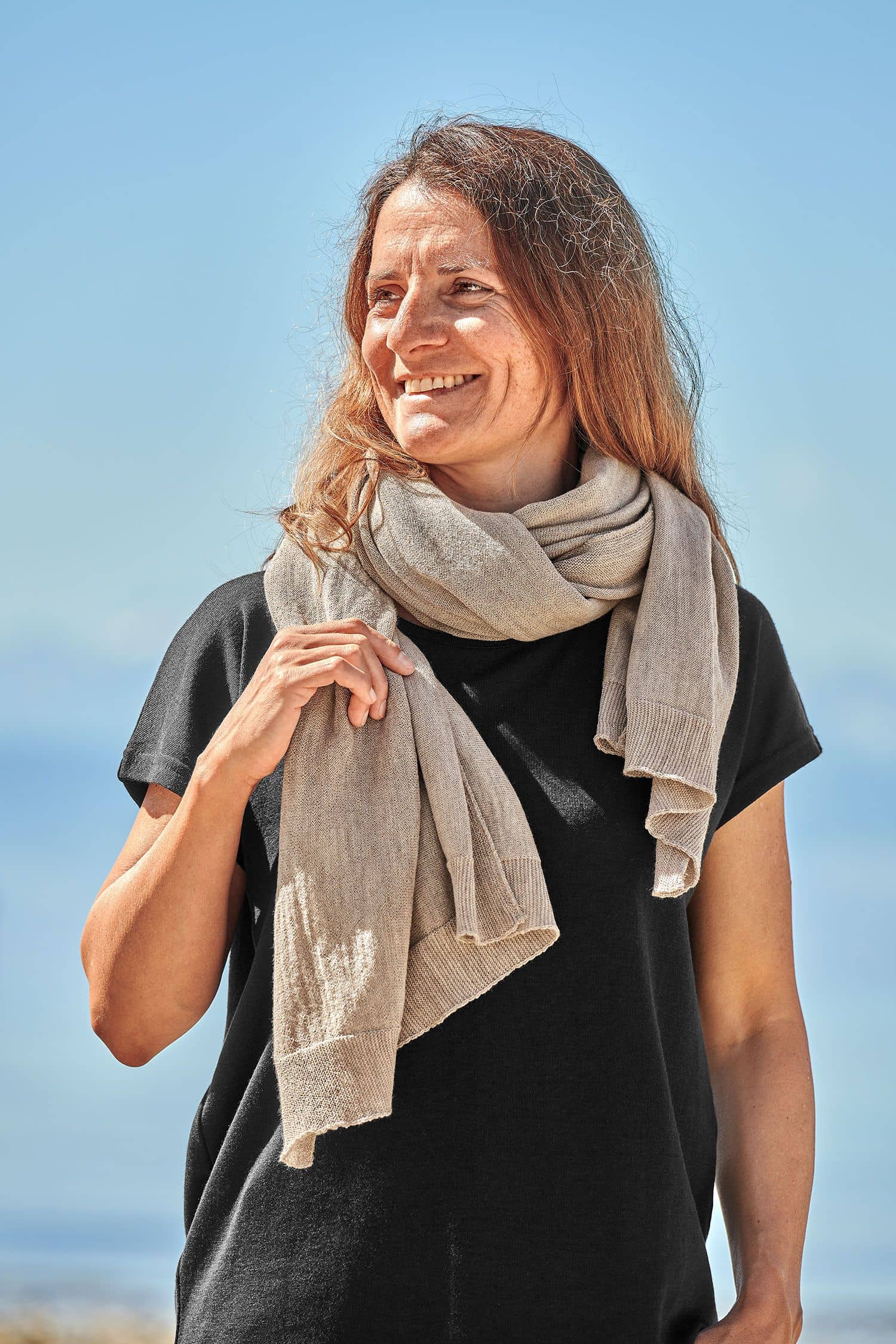 Feiner Merinoschal sand Frau mit schwarzem Shirt trägt einen beigen feinen Merinoschal aus bio Wolle (kbT) vom Finkhof