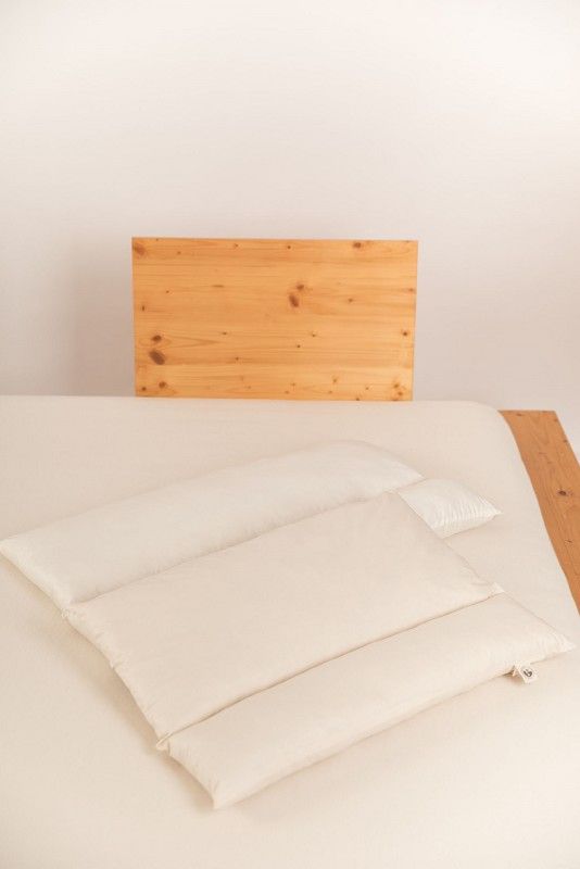 Rollenkissen Finkhof Rollenkissen aus bio Wolle (kbT) und bio Baumwolle (kbA) auf Holzbett