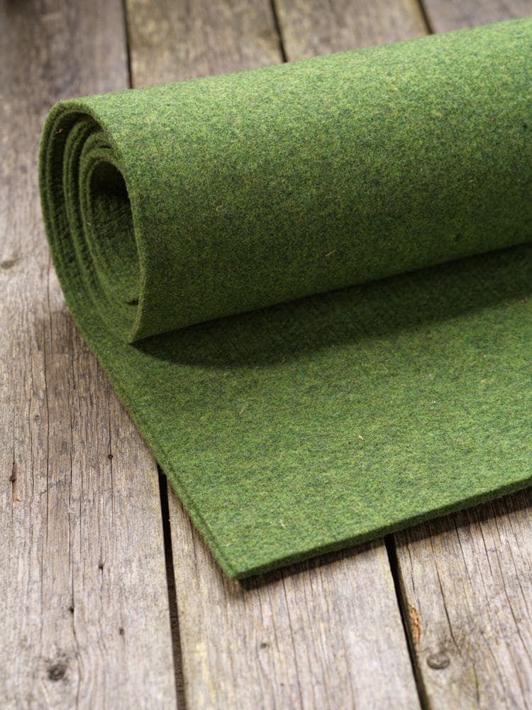 Finkhof-Nadelfilz grün grüne Rolle Finkhof Nadelfilz aus bio Wolle (kbT) auf braunem Holzboden