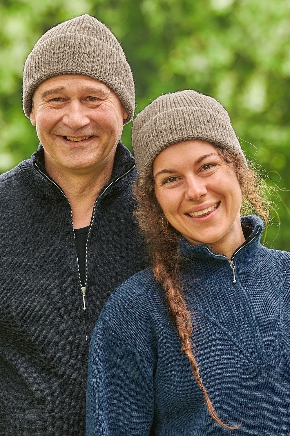 Frau und Mann tragen Troyer und graue Finkhof Wollmütze aus bio Wolle (kbT)