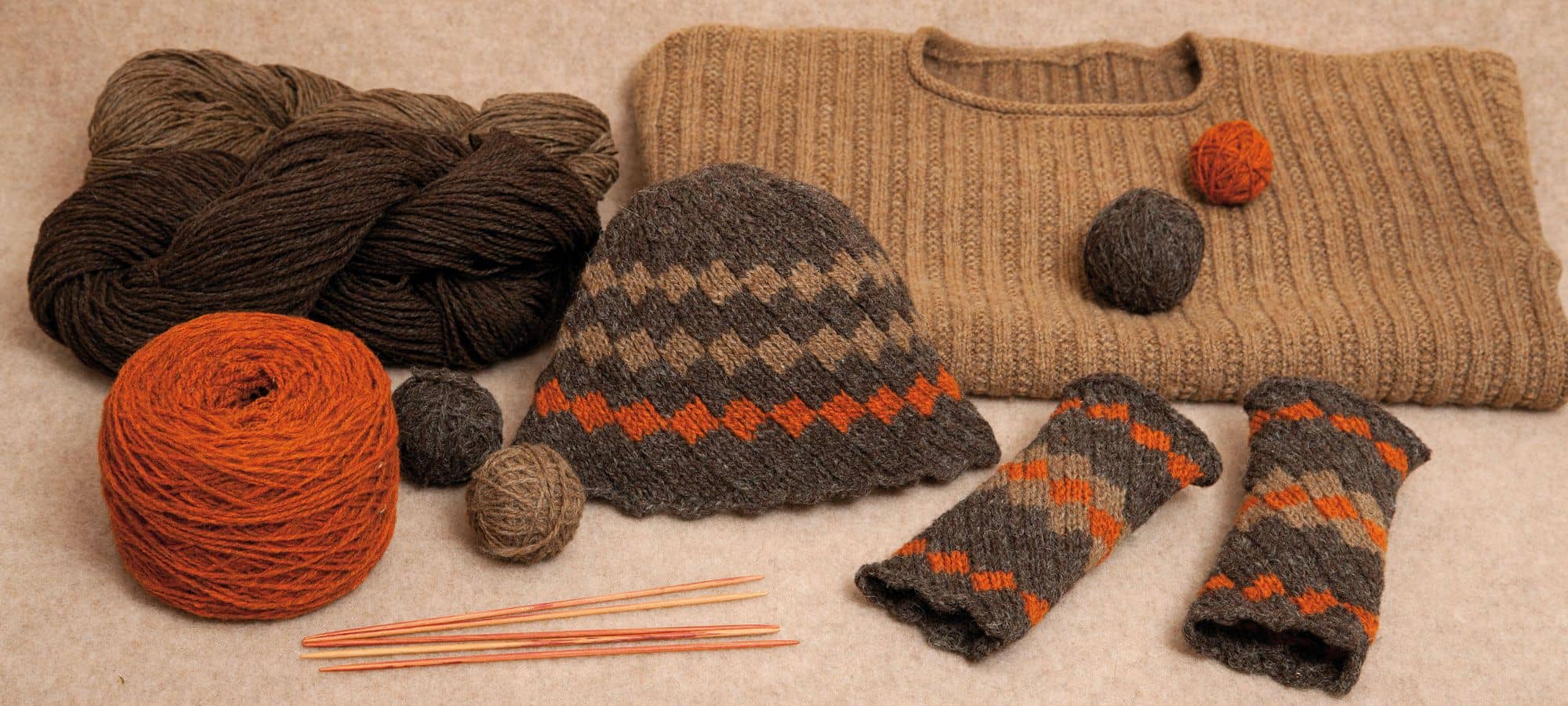 Strickanleitung Mütze und Stulpen Finkhof Banner für Mützen Stulpen in braun und orangetönen mit Pulli, Stulpen, Mütze und Knäulen