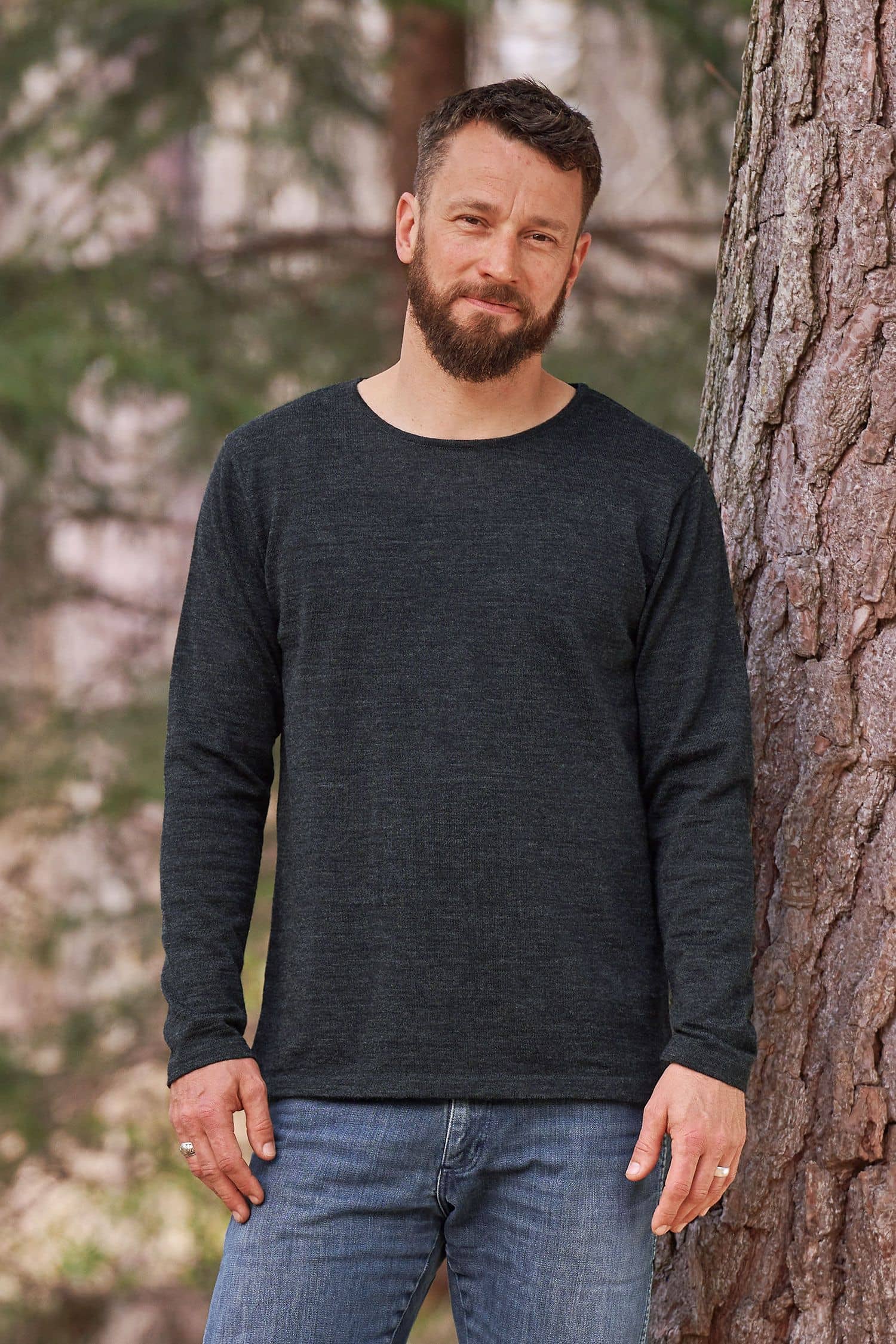 Mann steht vor Baum und trägt anthrazitgraues Wollshirt aus bio Wolle (kbT) vom Finkhof