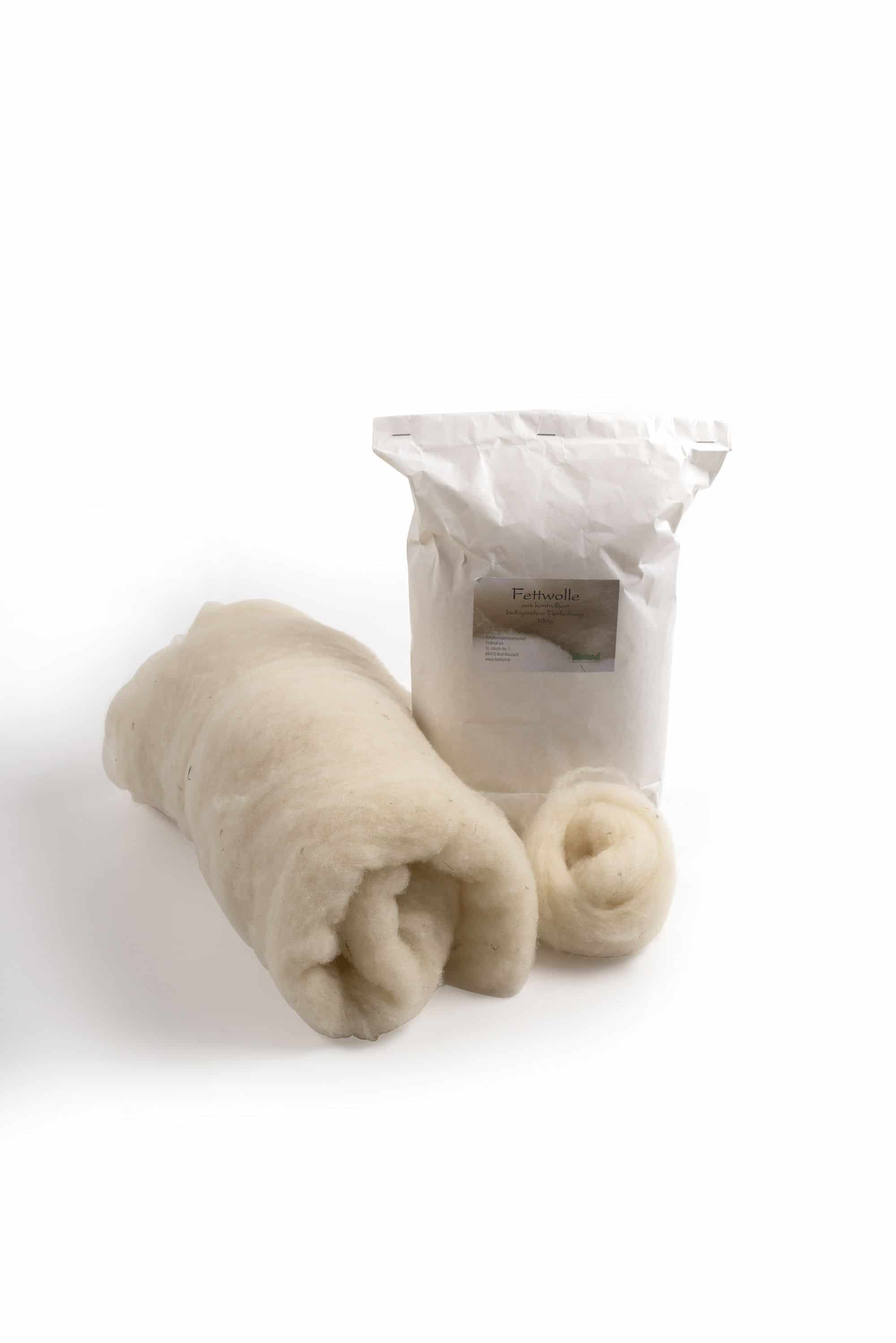 100g Packung Fettwolle vom Finkhof aus bio Wolle (kbT) mit aufgerollter Wolle davor