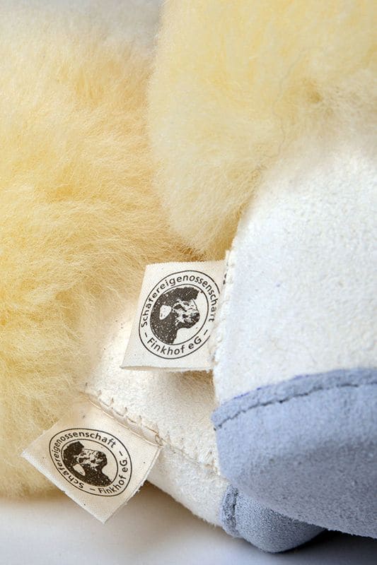 Nahaufnahme des Etiketts an der Ferse eines weißen Finkhof-Fellschuhs aus Relugan-Schaffell und Rindsleder