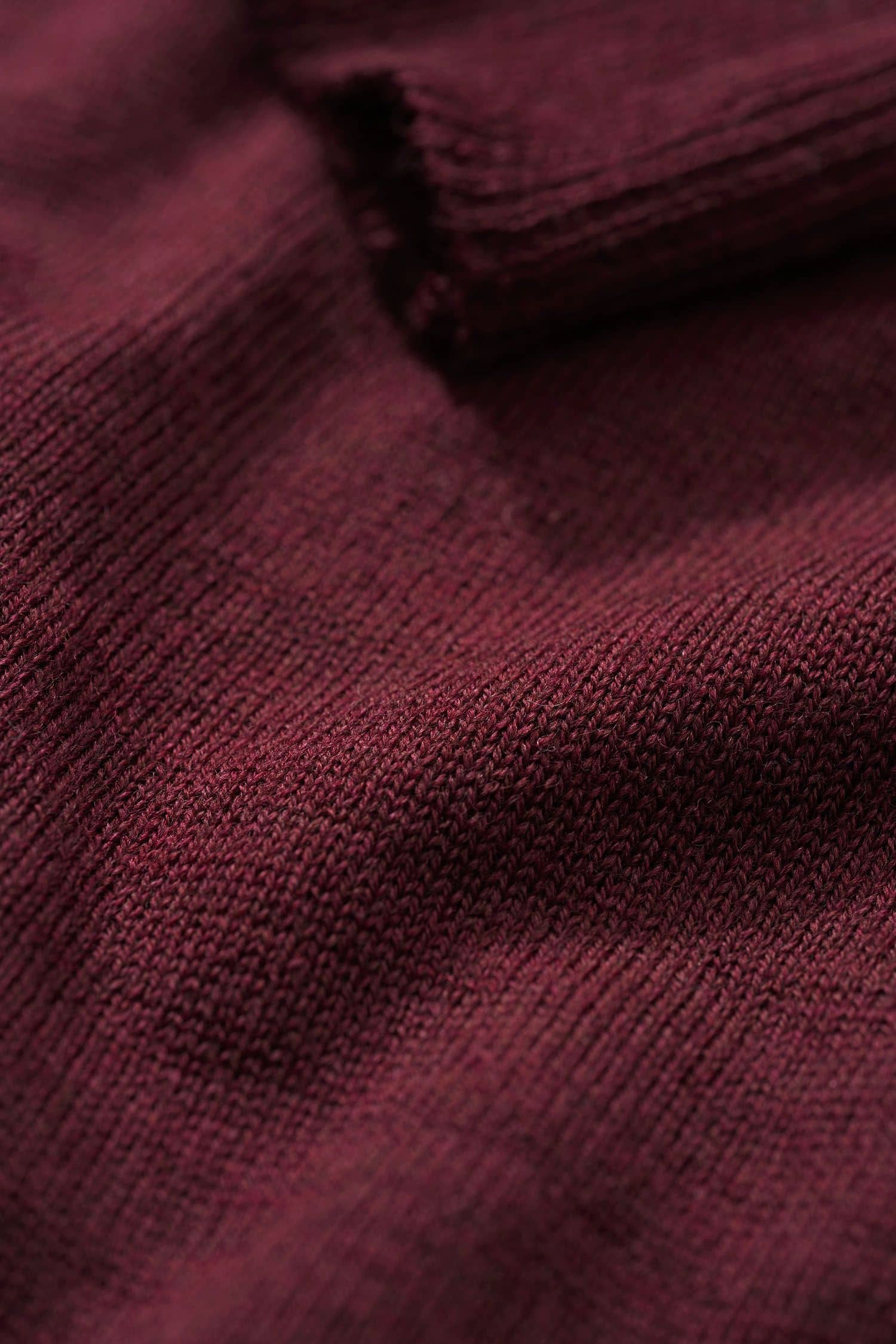 Detailaufnahme der Stoffstruktur des feinen burgunderroten Wollpullover aus bio Wolle (kbT) vom Finkhof