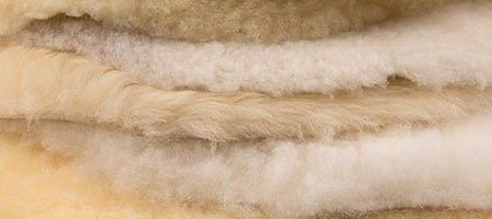 Finkhof Schaffelle weißlich und cremefarben übereinander, Nahaufnahme im Detail