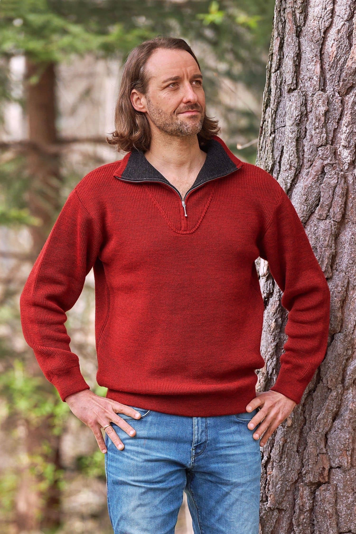 Mann steht vor Baum und trägt roten Troyer mit Reißverschluss vom Finkhof aus bio Wolle (kbT)