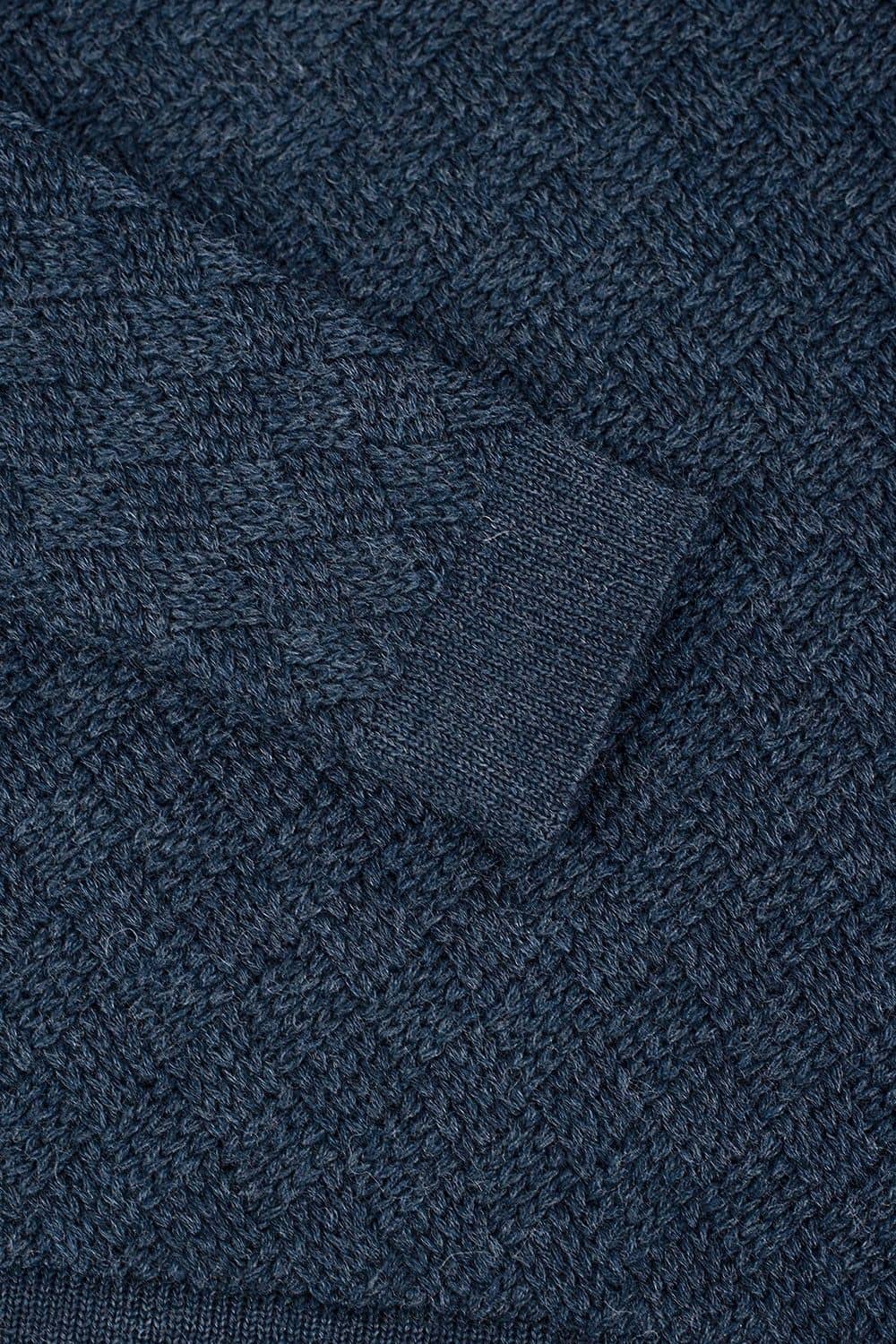 Detailaufnahme vom Ärmelbündchen und der Struktur des blauen Pullovers aus bio Wolle (kbT)