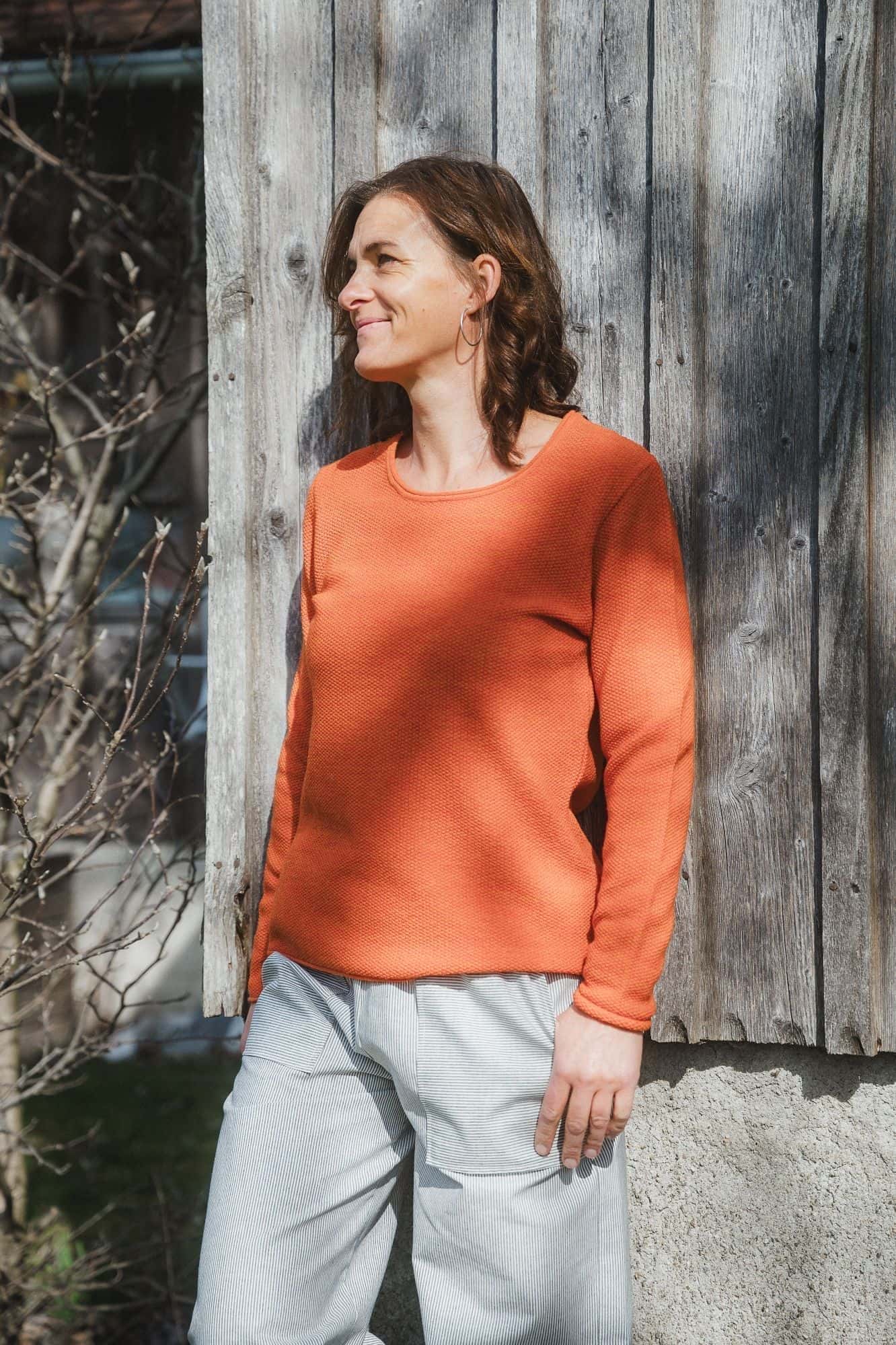 Frau trägt Bio Wollshirt Perle orangemeliert