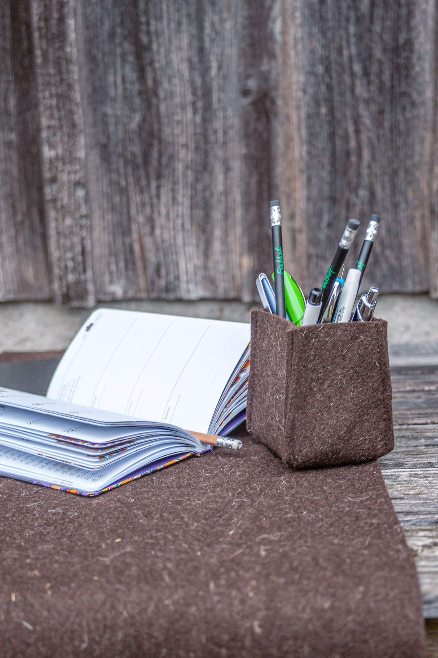 Stiftehalter als Beispiel für braunen Wollfilz aus bio Wolle (kbT) vom Finkhof und Kalender auf brauner Matte