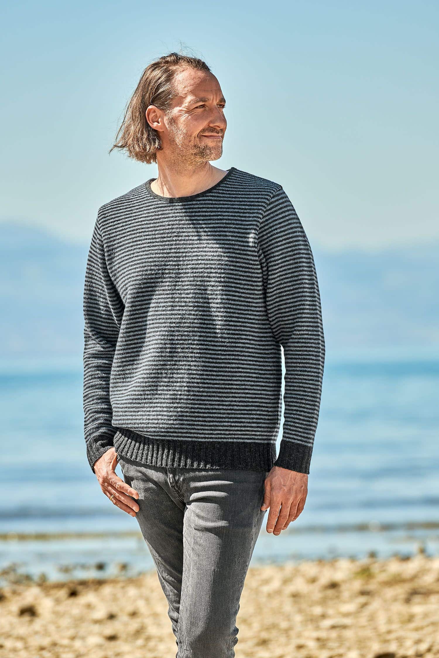 Mann trägt rauchblauen Streifenpulli aus bio Wolle (kbT) vom Finkhof