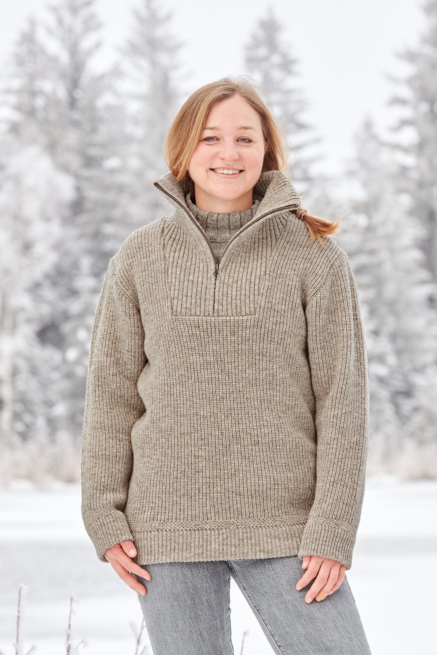 Frau in Schneelandschaft trägt grauen Finkhof Troyer aus bio Wolle (kbT)