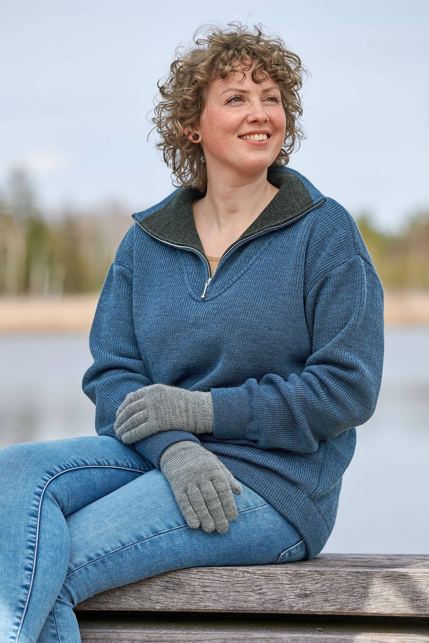 Frau mit blauem Troyer trägt graue Strickhandschuhe mit Fingern aus bio Wolle (kbT) vom Finkof