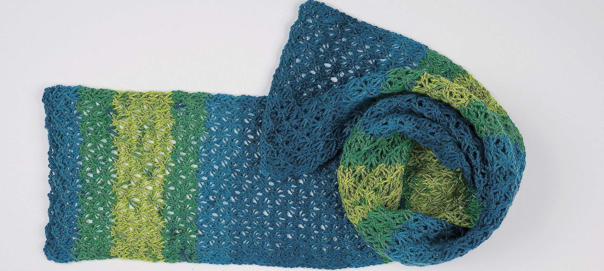 Strickanleitung kleiner Sternenschal Finkhof Banner für Anleitung zum blau grünen Sternenschal, der zur Schnecke aufgewickelt wurde