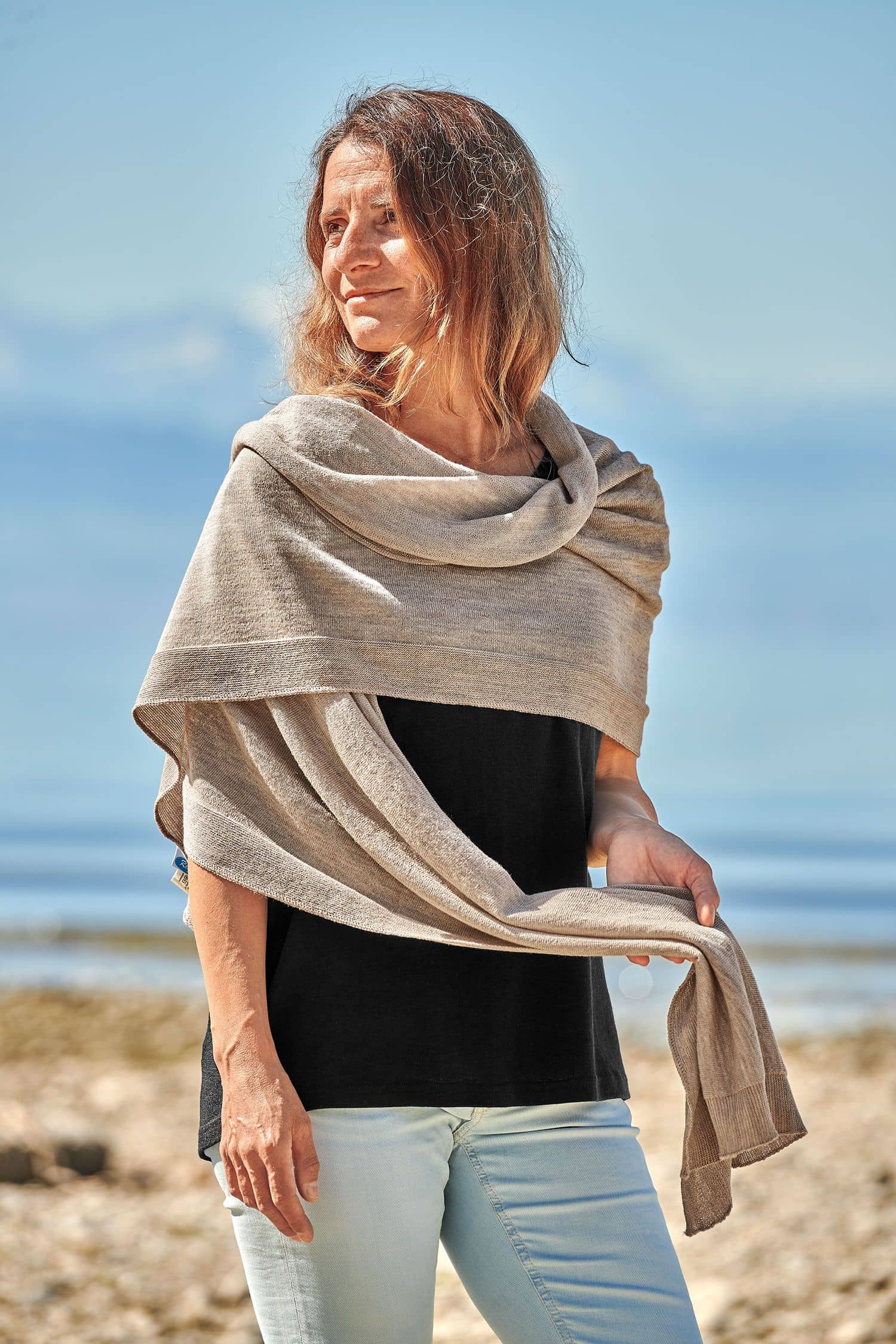 Frau mit schwarzem Shirt trägt einen beigen feinen Merinoschal aus bio Wolle (kbT) vom Finkhof