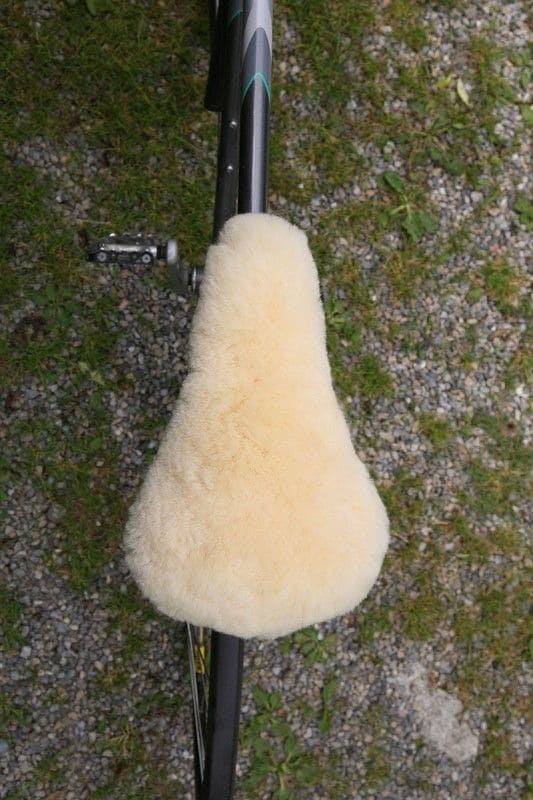 relugan gegerbter Finkhof Sattelbezug aus bio Wolle (kbT) und Schaffell auf dunklem Fahrrad von oben