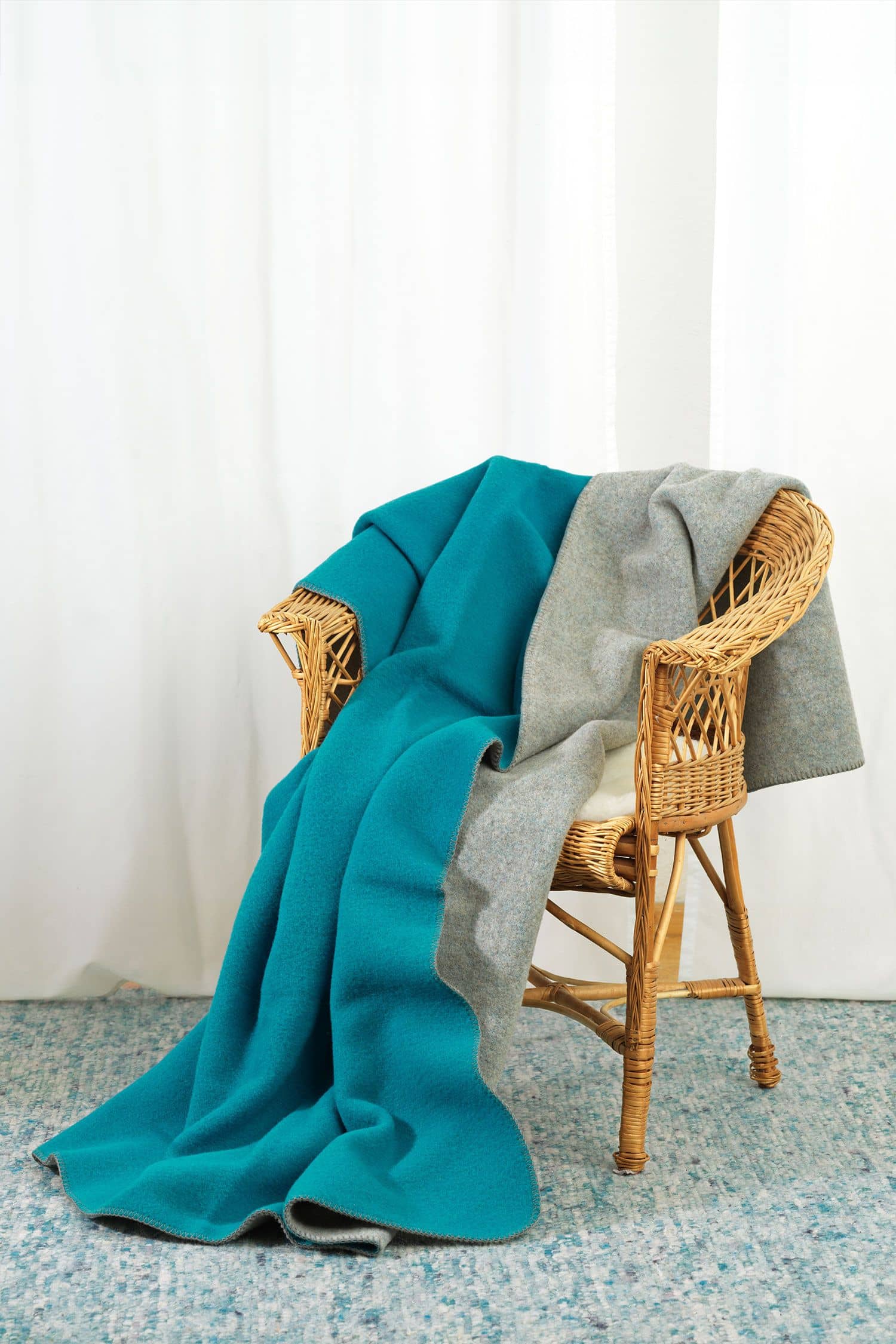 Finkhof-Wolldecke Doubleface türkis/grau 100 x 150 cm Finkhof Wolldecke Doubleface aus bio Wolle (kbT) vom Merinolandschaf in türkis grau über Stuhllehne gehängt