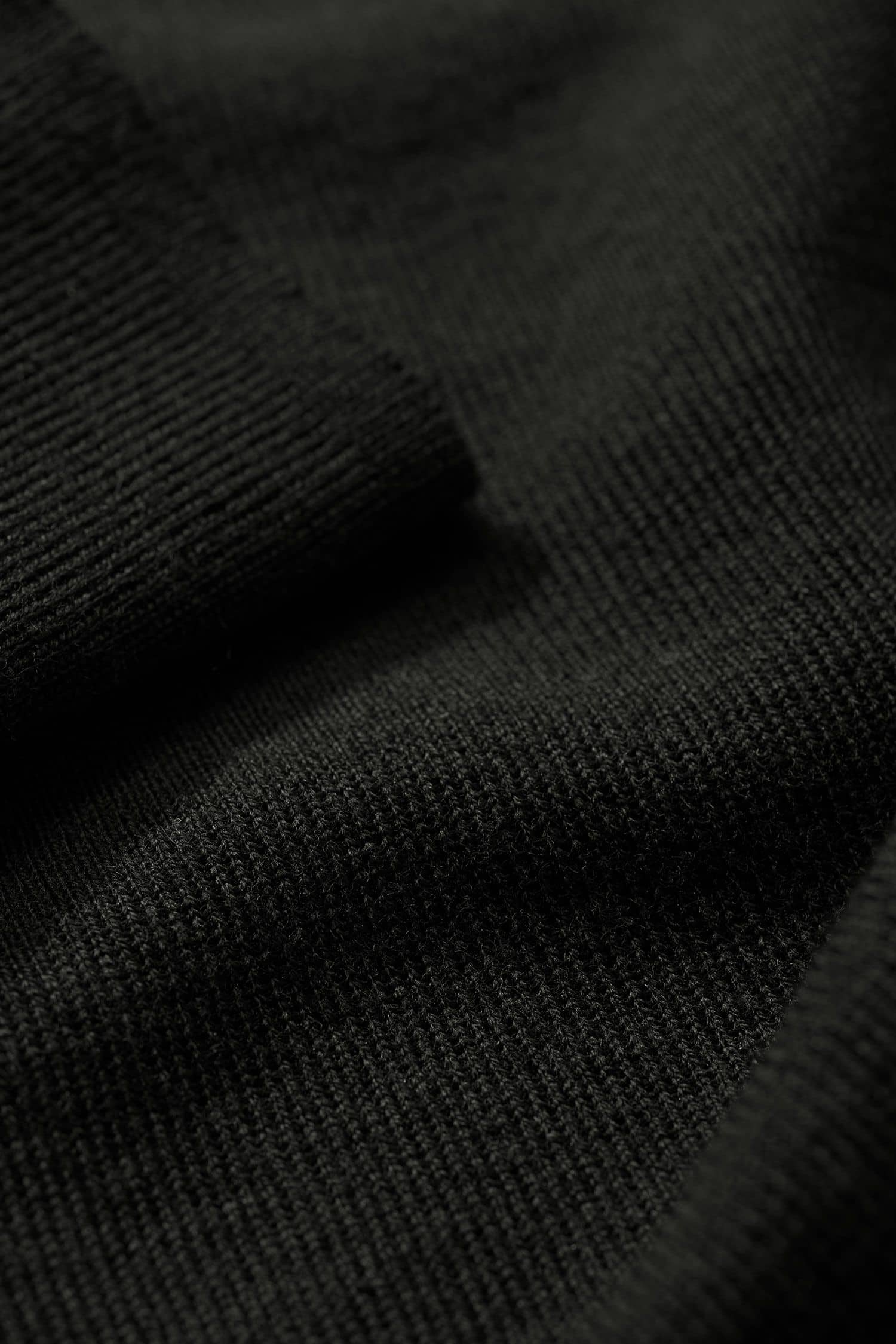 Detailaufnahme der Stoffstruktur des schwarzen Rollkragenpullover aus bio Merinowolle (kbT) vom Finkhof