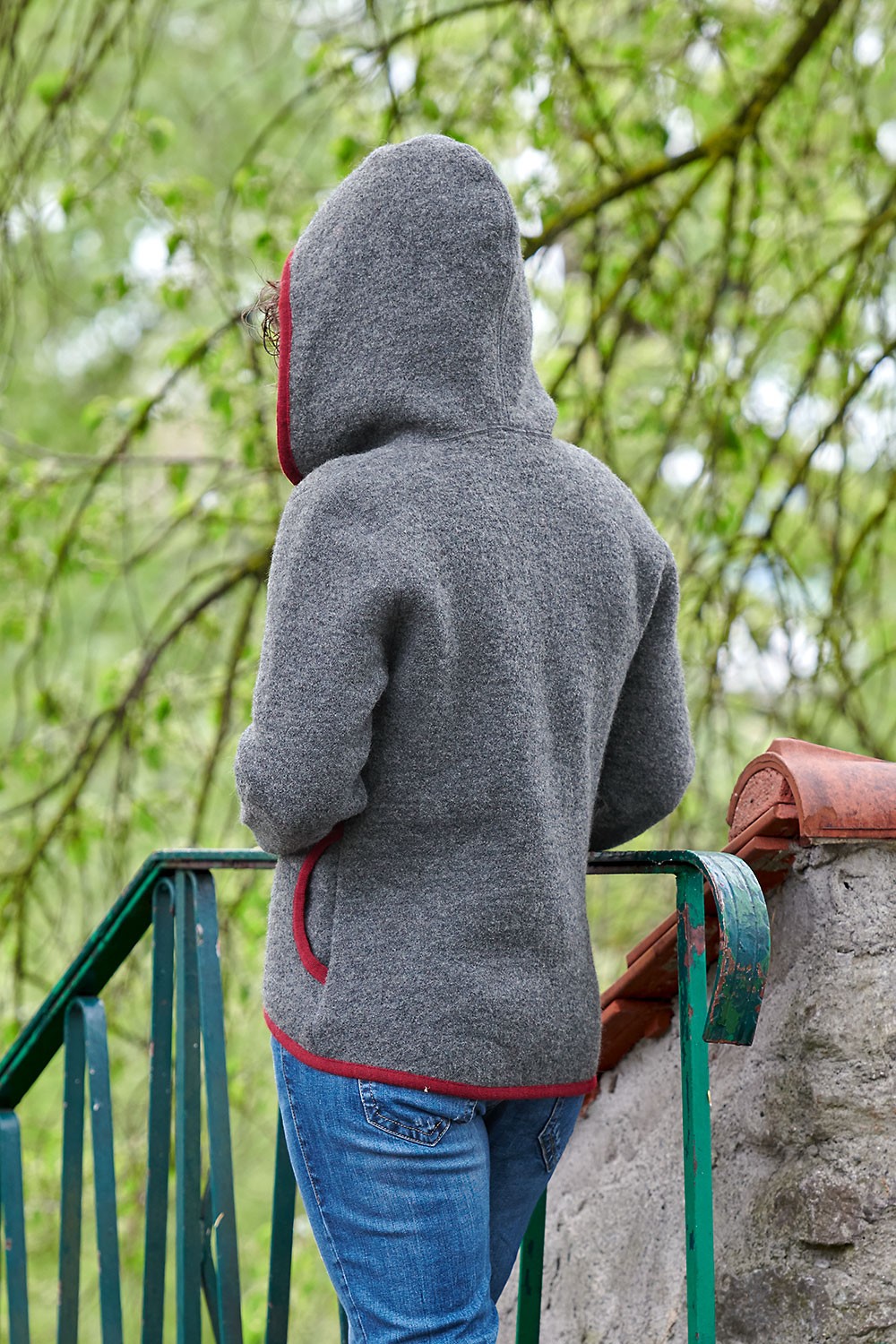 Rückansicht von Frau mit grauer Kapuzenjacke aus einem Strickwalk aus bio Wolle (kbT) vom Finkhof
