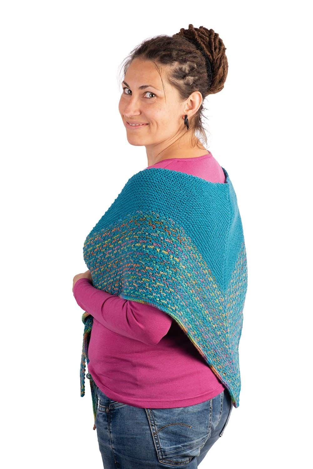 Frau mit pinkem Shirt hat Stricktuch aus petrolfarbener Finkhof Sockenwolle aus bio Wolle (kbT) über den Schultern