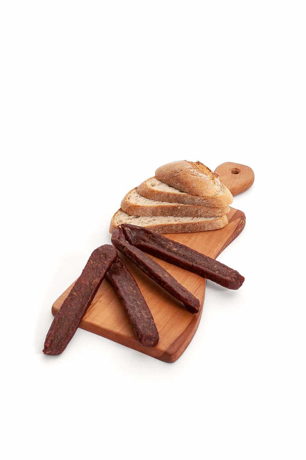 Finkhof Lammjäger auf Brettchen mit Brotscheiben auf weißem Untergrund